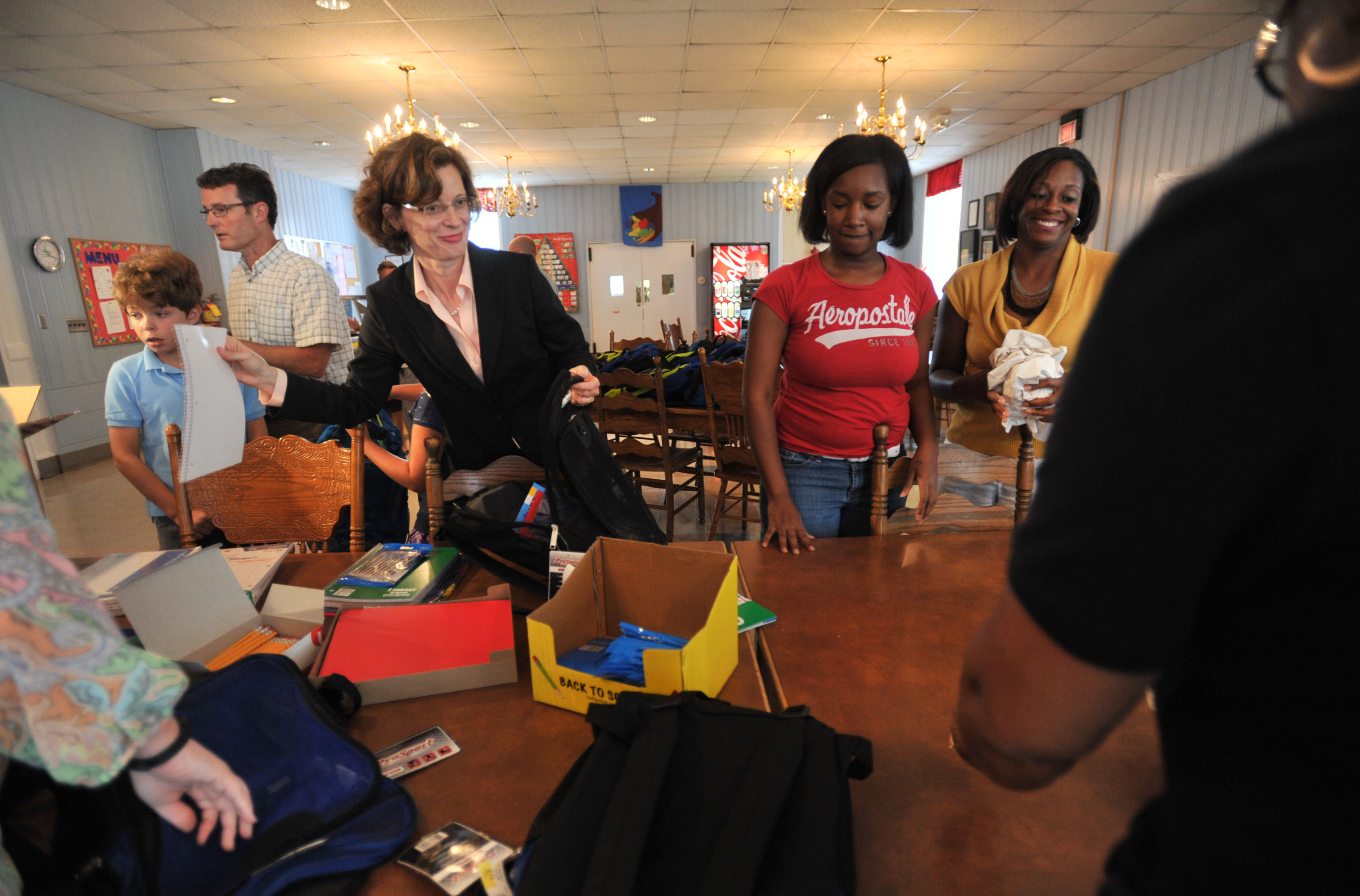 With the help of son, Vinson, left, and husband Ron, U. S. Senate candidate Michelle Nunn and other volunteers stuffed book bags with school supplies for residents of the Georgia Industrial Childrens Home, Aug. 7, 2013. (Beau Cabell—The Telegraph/AP)