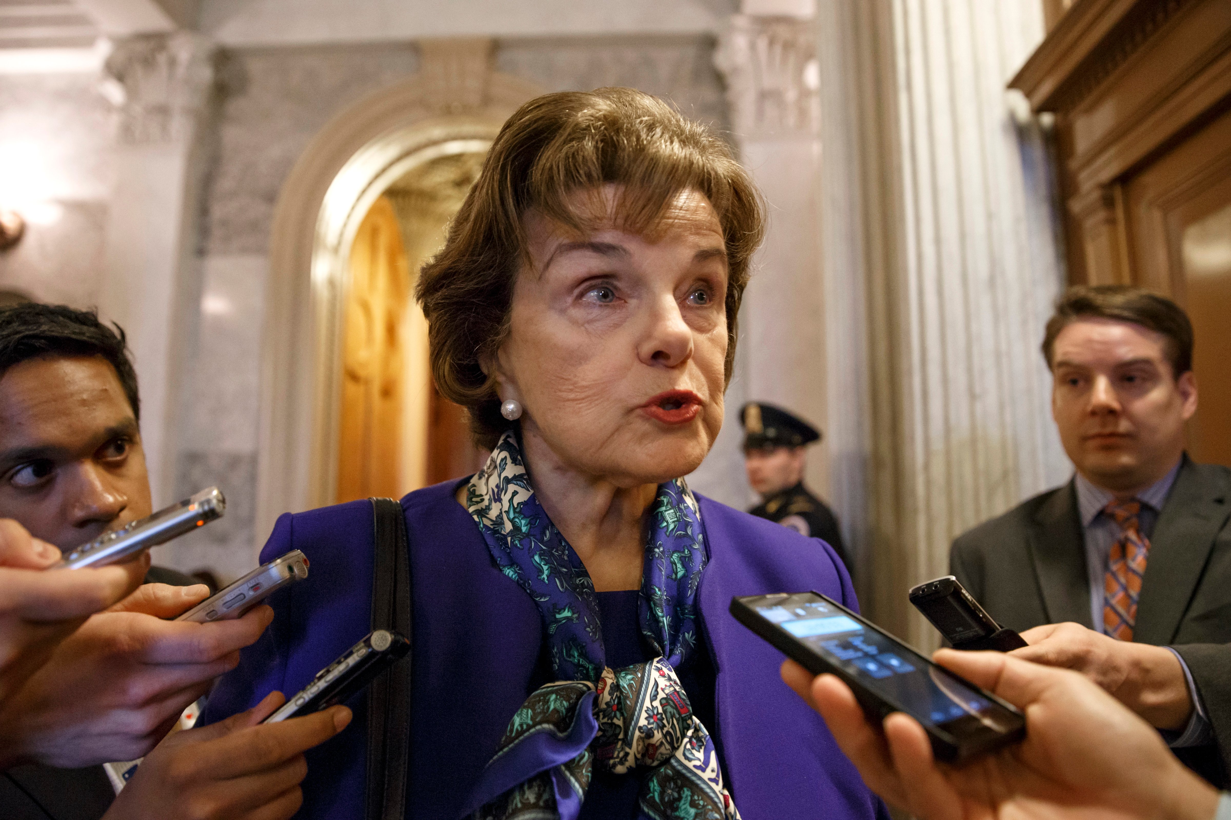 Senate Intelligence Committee Chair Senator Dianne Feinstein talks to reporters as she leaves the Senate chamber on Capitol Hill in Washington, Tuesday, March 11, 2014, after saying that the CIA's improper search of a stand-alone computer network established for Congress has been referred to the Justice Department. The issue stems from the investigation into allegations of CIA abuse in a Bush-era detention and interrogation program. (AP Photo/J. Scott Applewhite)