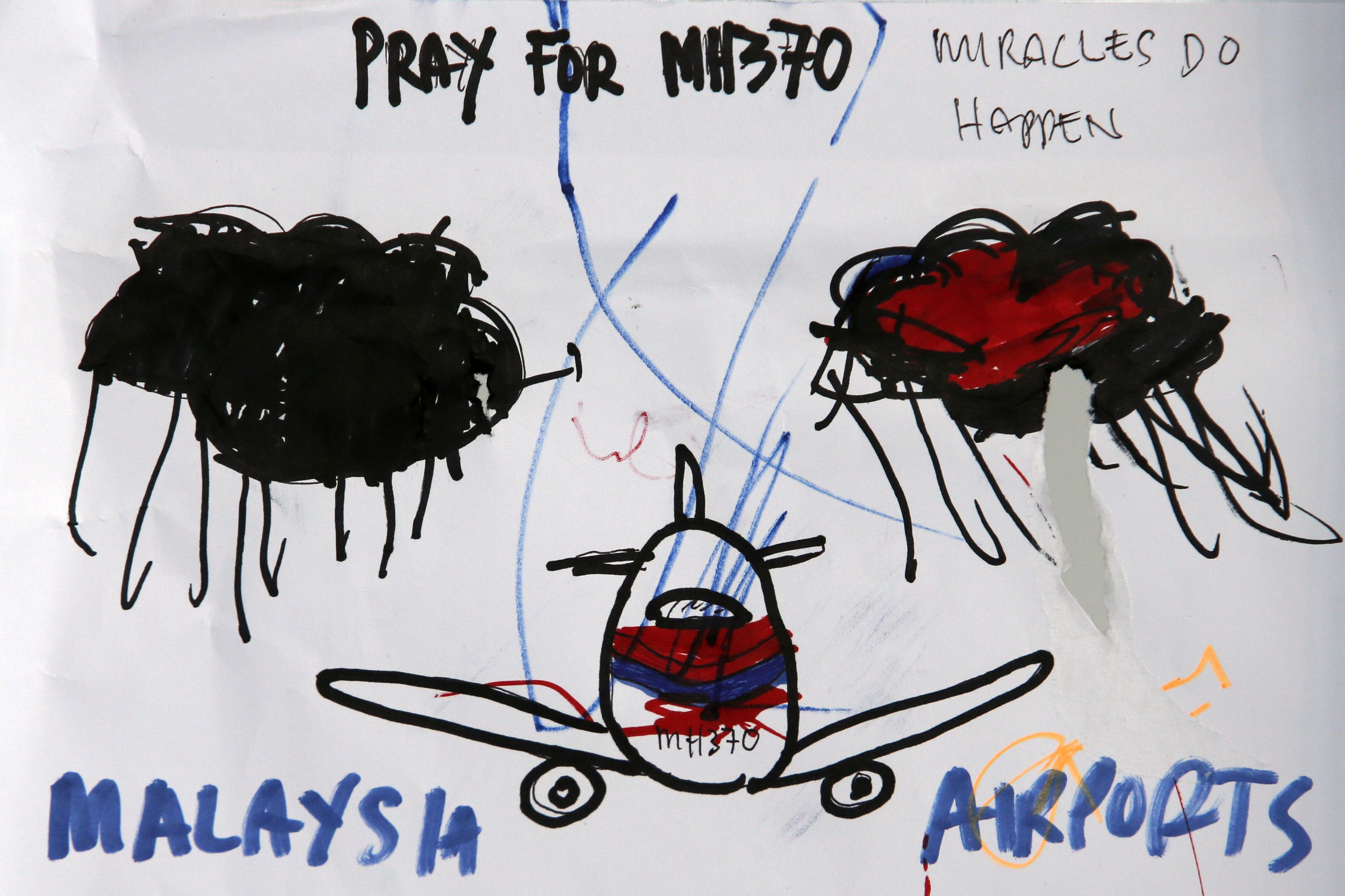 Children's artworks hoping for the safe return of Flight MH370's passengers and crew are seen hanging at Kuala Lumpur International Airport, March 19, 2014.