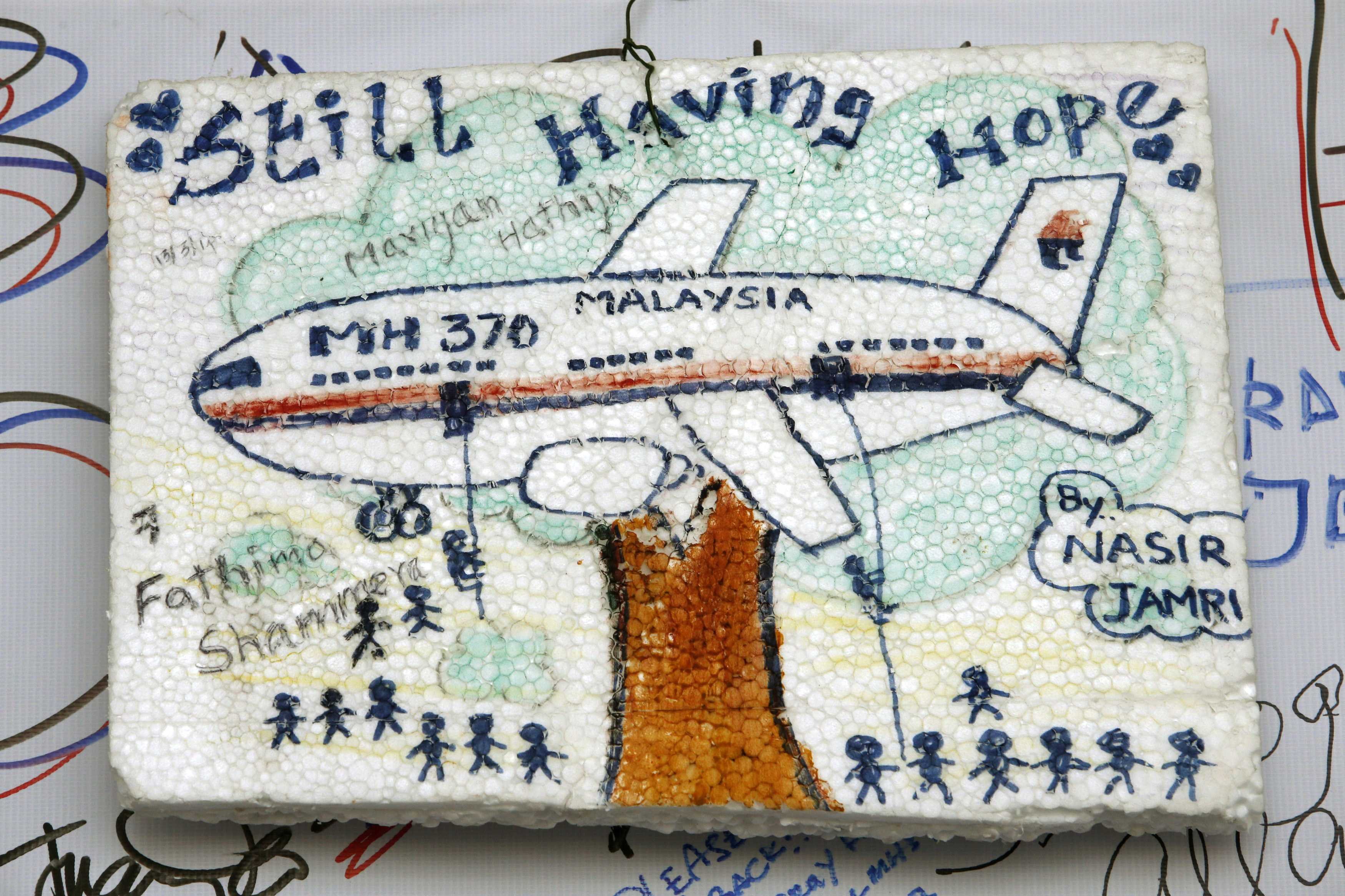 Children's artworks hoping for the safe return of Flight MH370's passengers and crew are seen hanging at Kuala Lumpur International Airport, March 19, 2014.