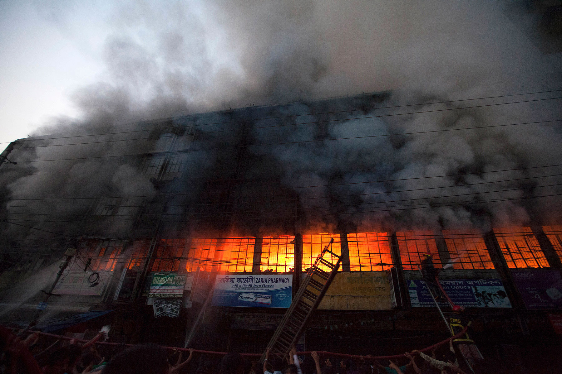 Locals and fire-fighters try to control a fire at a garment factory in Dhaka March 6, 2014 (Reuters)