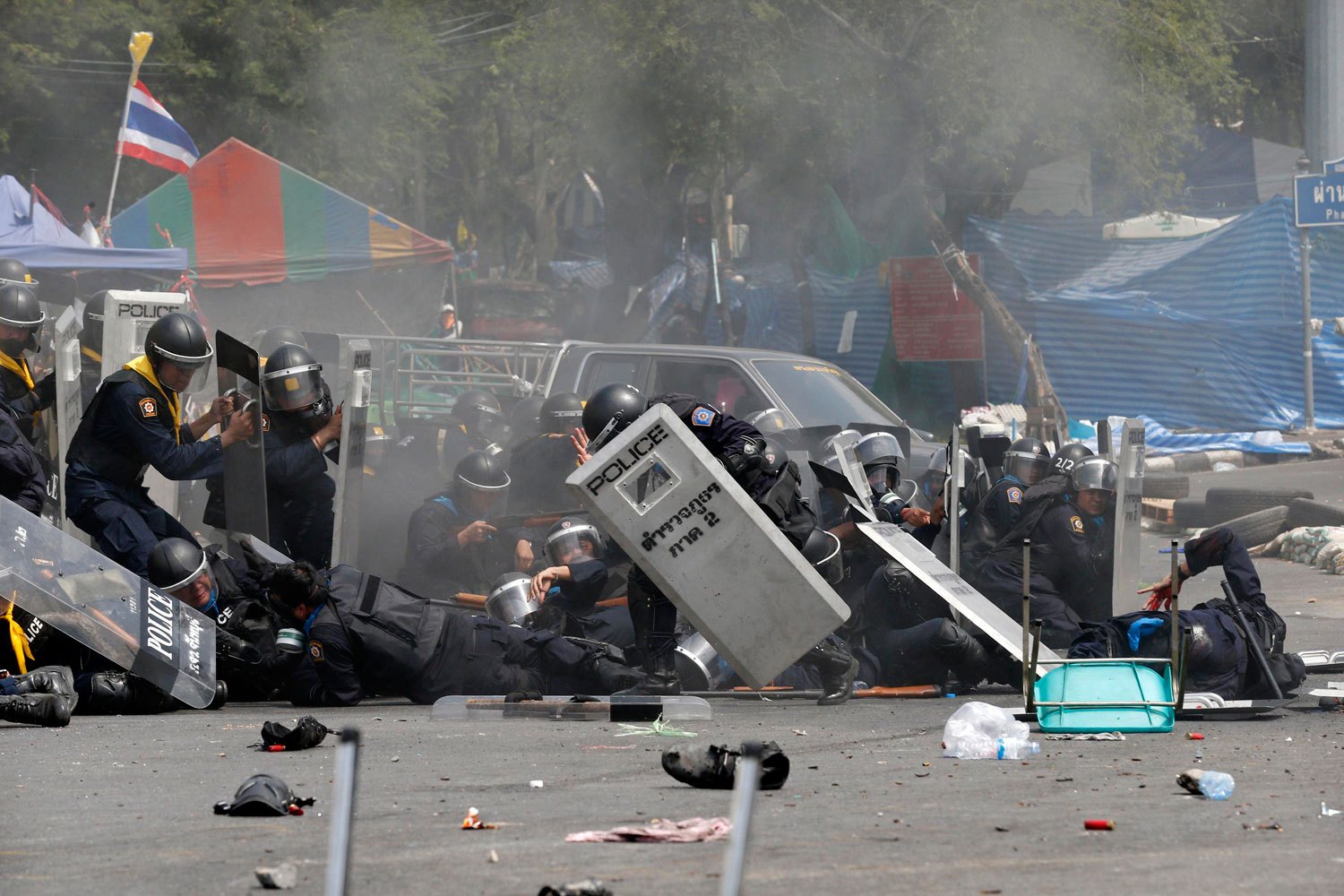 Thai police officers react after an explosion during clashes with anti-government protesters near Government House in Bangkok, on Feb. 18, 2014.