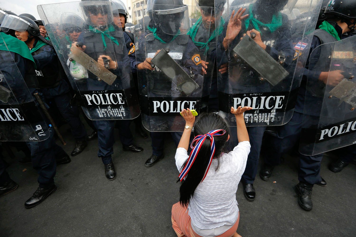 An anti-government protester pushes a line of policemen during clashes near the Government House in Bangkok, on Febr. 18, 2014.