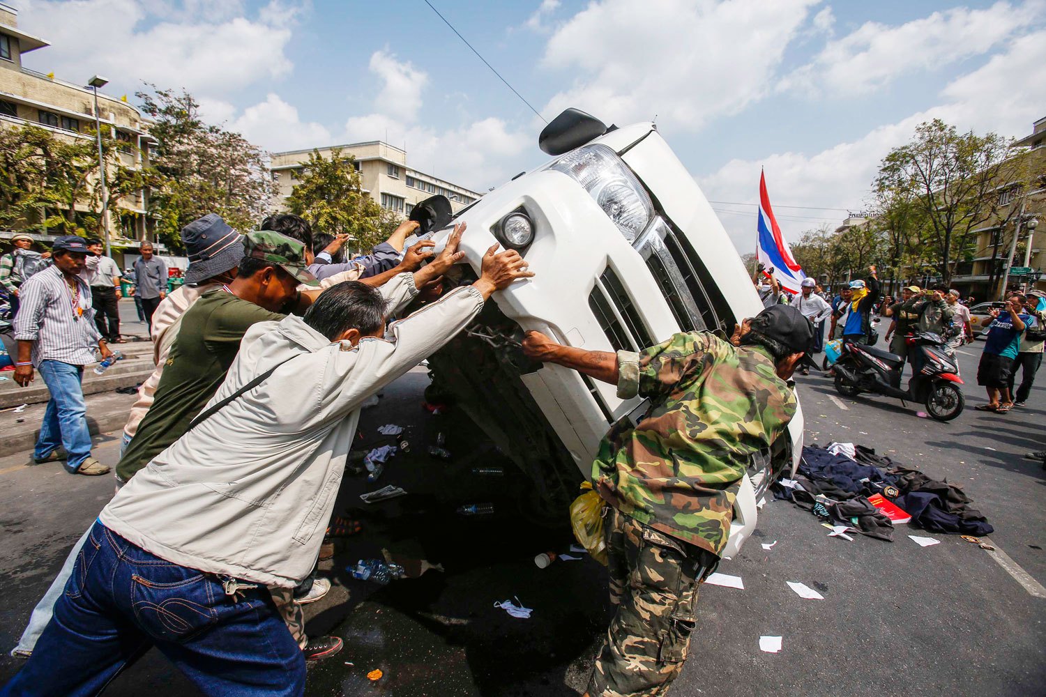 Anti-government protesters lift a police car after clashes with Thai riot police officers near Government House in Bangkok, on Feb. 18, 2014.