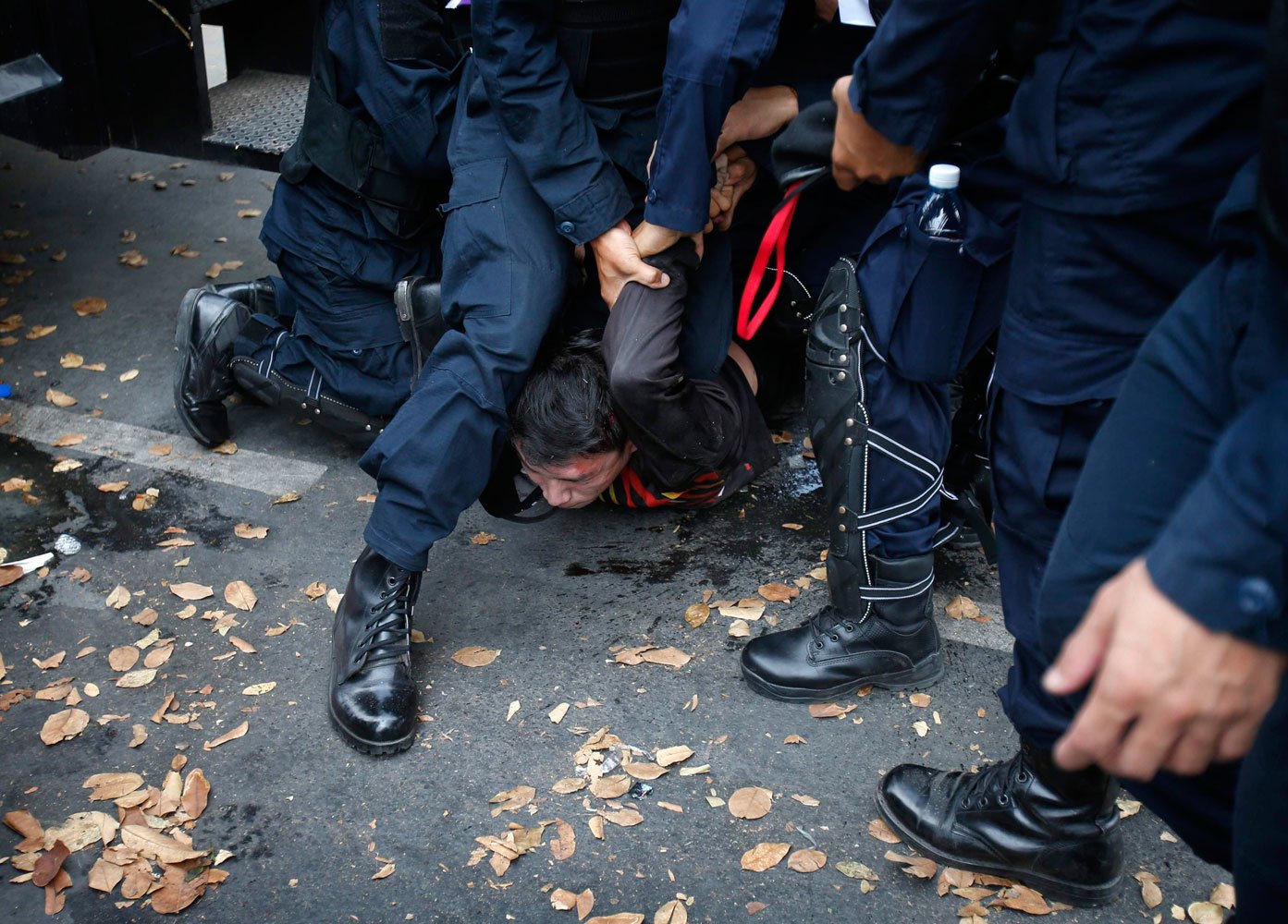 Thai police officers detain an anti-government protester near Government House in Bangkok, on Feb. 18, 2014.