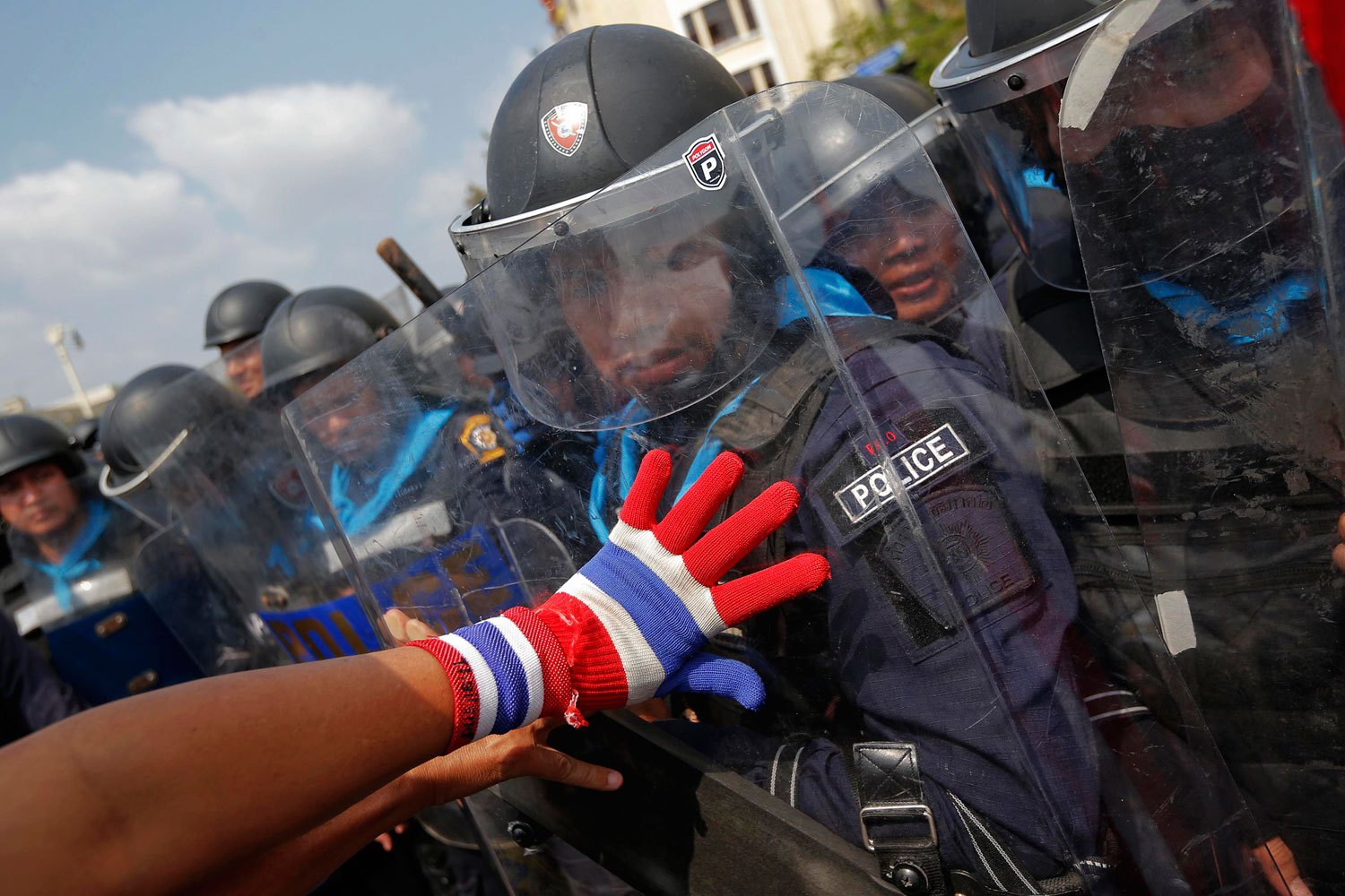 An anti-government protester pushes policemen during clashes near the Government House in Bangkok, on Feb. 18, 2014.