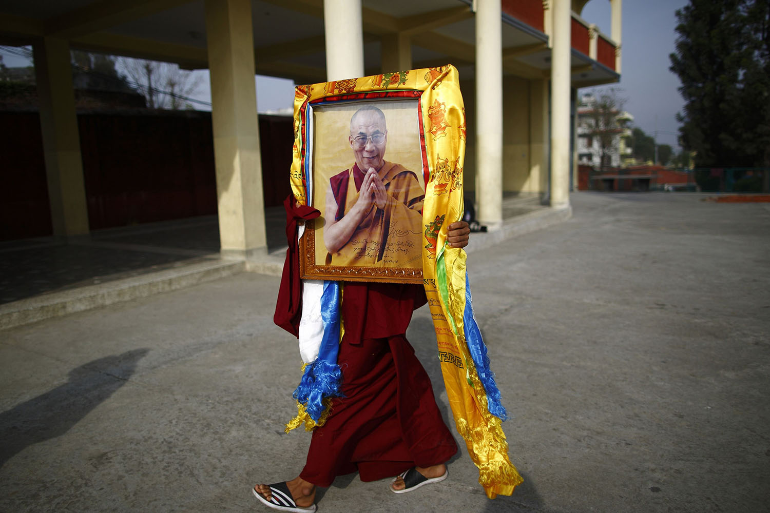 Mar. 4, 2014. A Tibetan monk carries a portrait of exiled Tibetan spiritual leader, the Dalai Lama, during a function organised to mark  Losar  or the Tibetan New Year in Kathmandu.