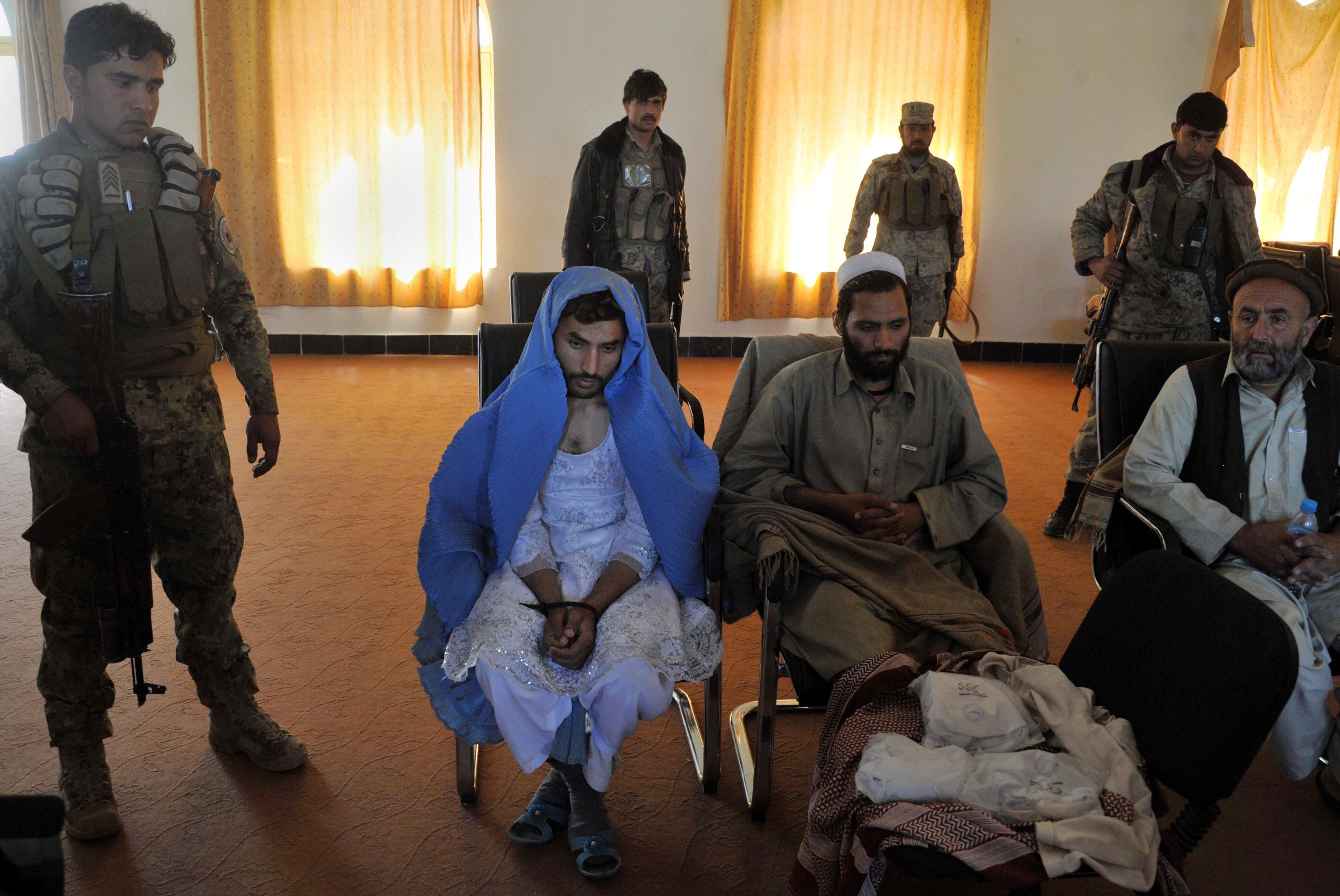 Mar. 18,2014. Afghan security personnel present a burqa-clad resident they say is a Taliban fighter to the media at the Afghan National Army headquarters in Khogyani District near Jalalabad. Three Taliban insurgents have been arrested in possession of heroin by Afghan Joint Forces during an operation in the Khogyani District of Nangarhar province.