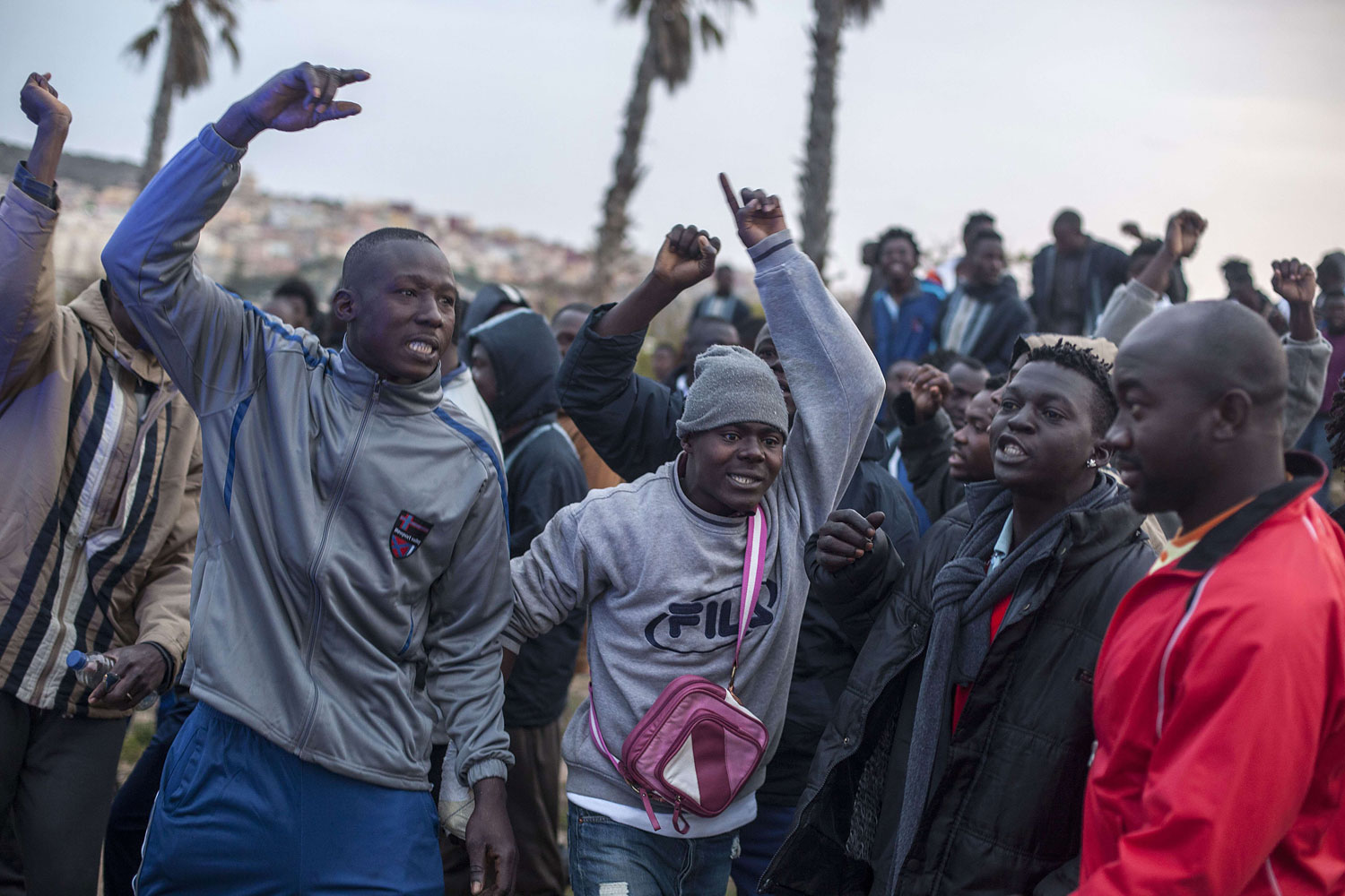 Would-be immigrants of the Centre for Temporary Stay of Immigrants cheer others who want to cross the fence near Beni Enza, into the north African Spanish enclave of Melilla on March 28, 2014.