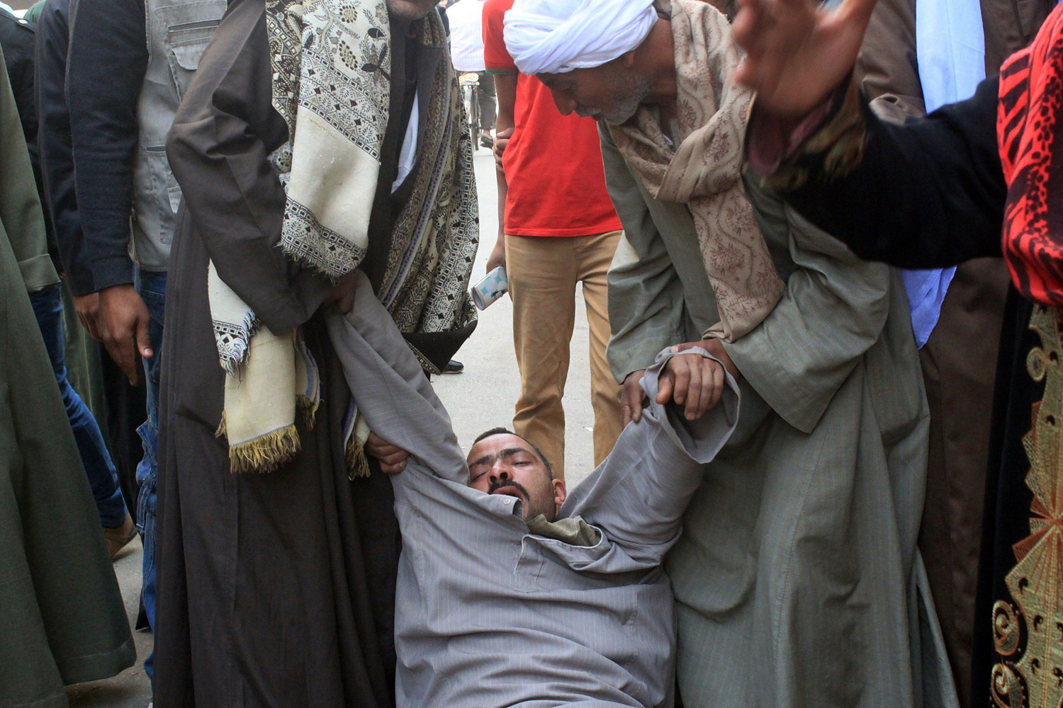 A relative of a supporter of Egyptian ousted Islamist president Mohamed Morsi is supported as he faints outside the courthouse on March 24, 2014 in the central Egyptian city of Minya, after the court ordered the execution of 529 Morsi supporters after only two hearings. (AFP/Getty Images)