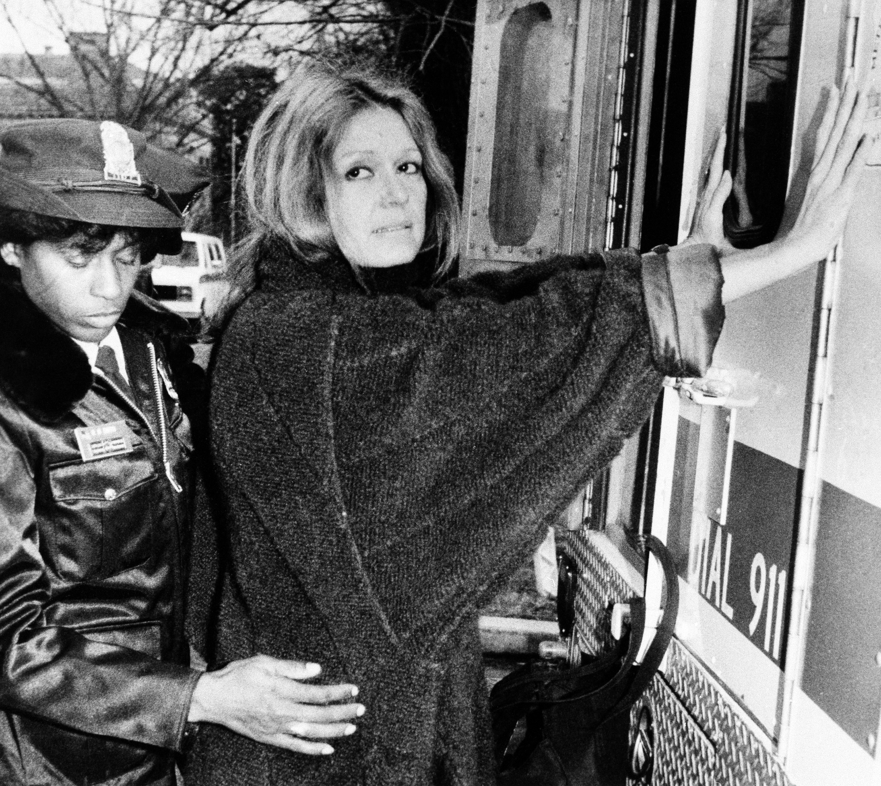 A uniformed officer arrests feminist Gloria Steinem during an anti-apartheid protest outside the South African Embassy in Washington, Dec. 19, 1984. (AP)