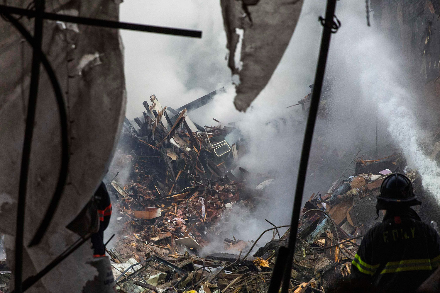New York City emergency responders search through the rubble at the site of a building explosion in the Harlem section of New York, March 13, 2014. 