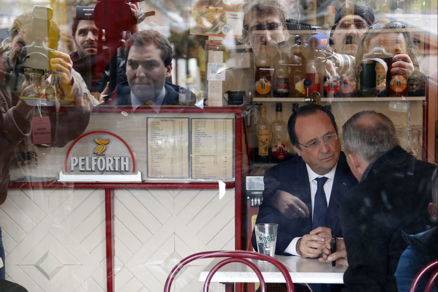 France's President Francois Hollande is seen speaking in a bar after voting in the first round in the French mayoral elections in Tulle