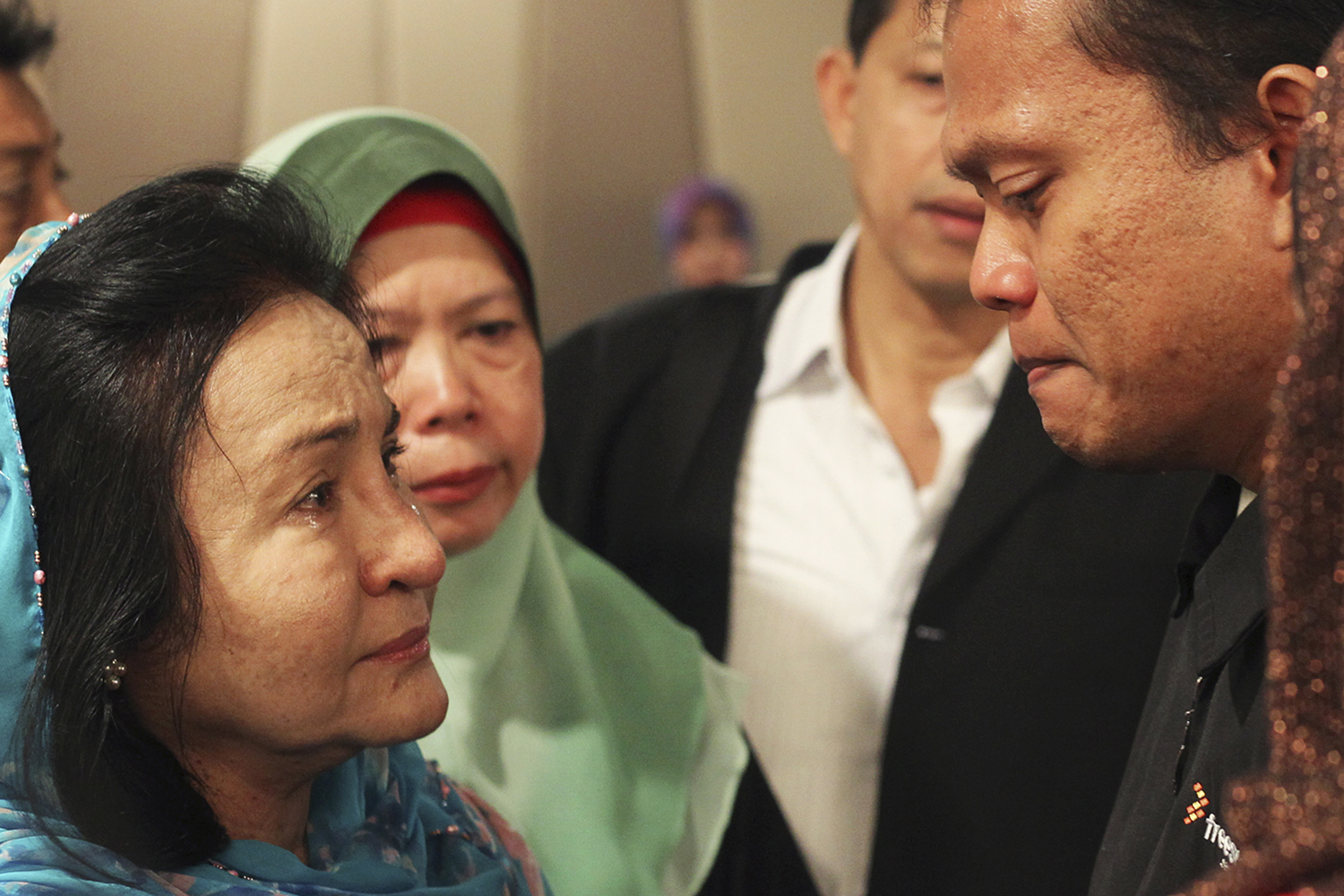 Rosmah Mansor, left, wife of Malaysian Prime Minister Najib Razak, cries with family members of passengers on the missing Malaysia Airlines flight MH370, at a hotel in Putrajaya March 9, 2014. (Zulfadli Zaki—Reuters)