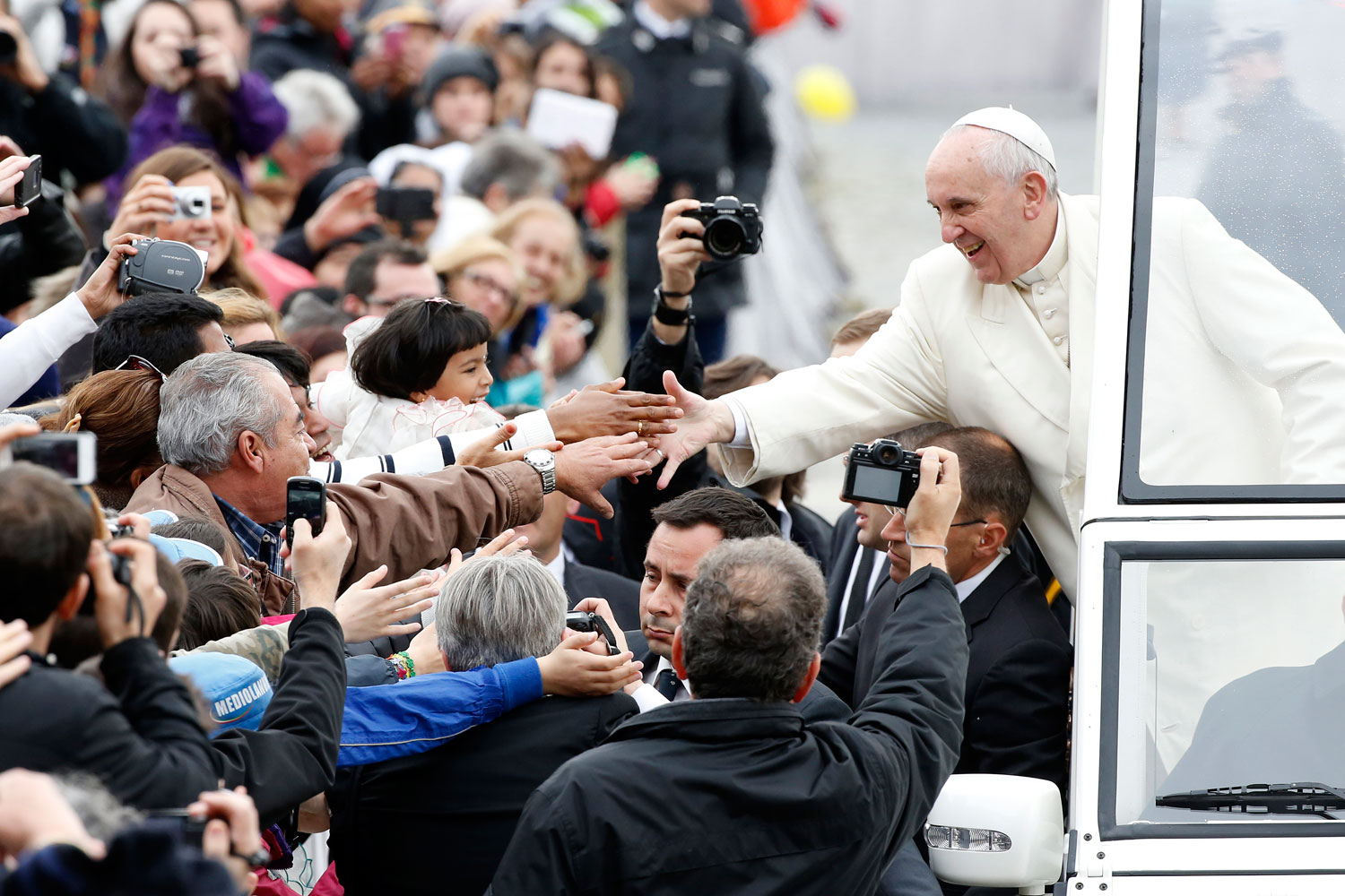 Pope Francis reaches out to greet the faithful as he arrives to lead his Wednesday general audience in Saint Peter's Square at the Vatican March 26, 2014. (Tony Gentile—Reuters)