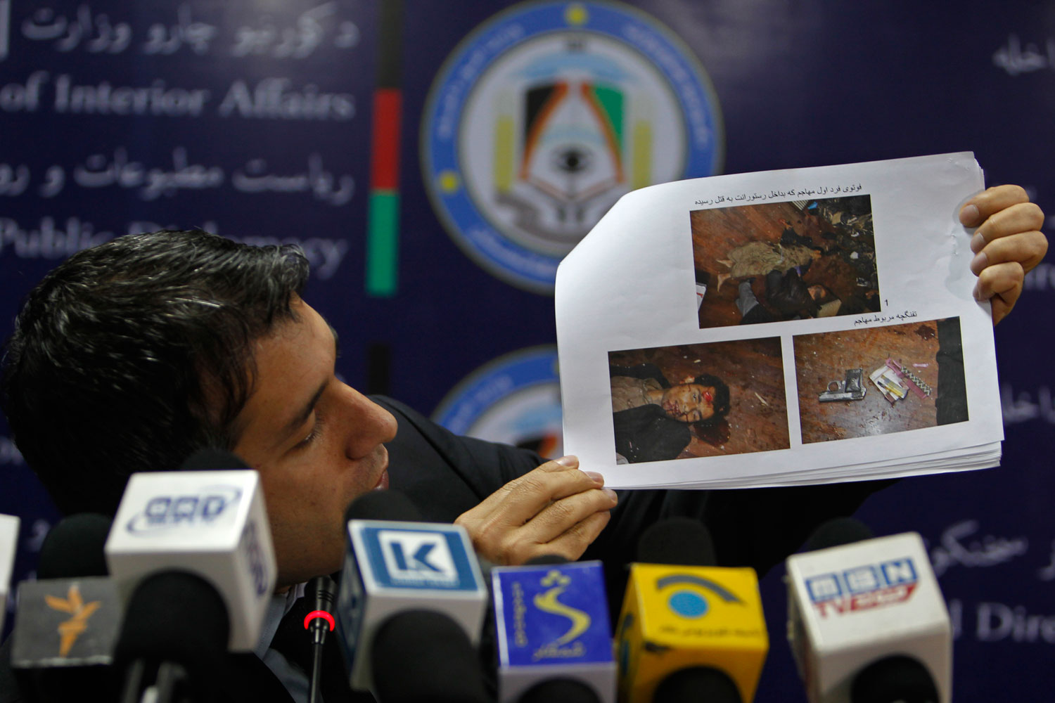 Afghanistan's interior ministry spokesman Sediq Sediqqi shows pictures of Taliban insurgents that were killed last night in a luxury hotel in Kabul March 21, 2014. (Omar Sobhani—Reuters)