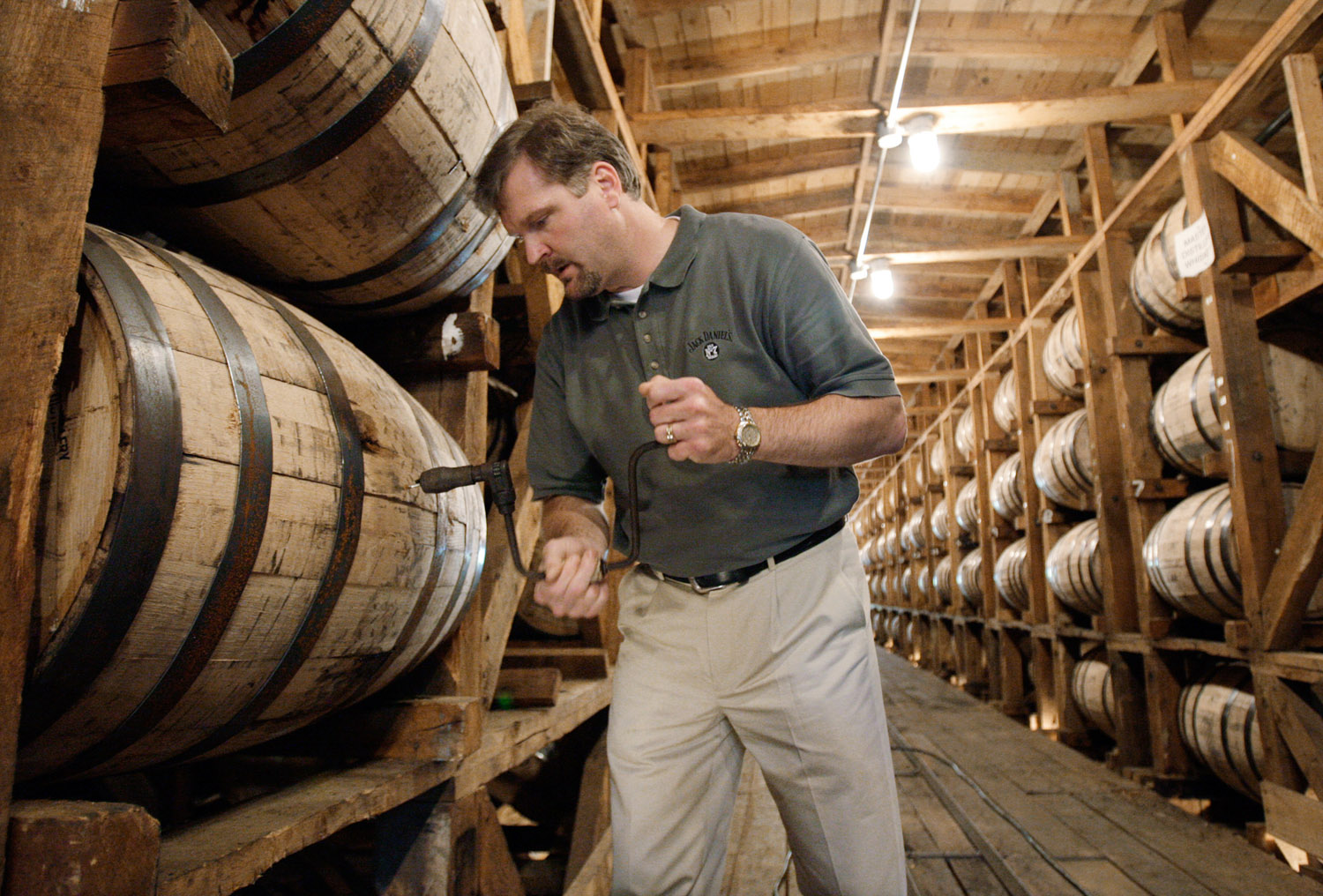 Jeff Arnett, the master distiller at the Jack Daniel Distillery in Lynchburg, Tenn., drills a hole in a barrel of whiskey in one of the aging houses at the distillery, May 20, 2009.