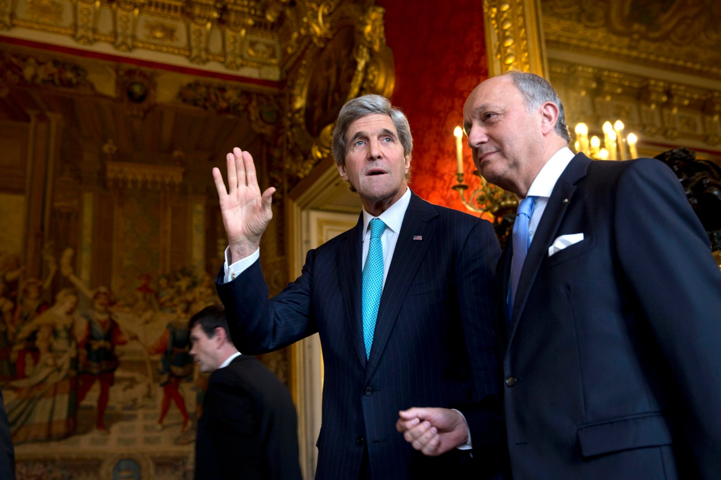 From left: U.S. Secretary of State John Kerry waves to the waiting media as he walks with French Foreign Minister Laurent Fabius for their meeting at the Quai d'Orsay in Paris, on March 30, 2014.