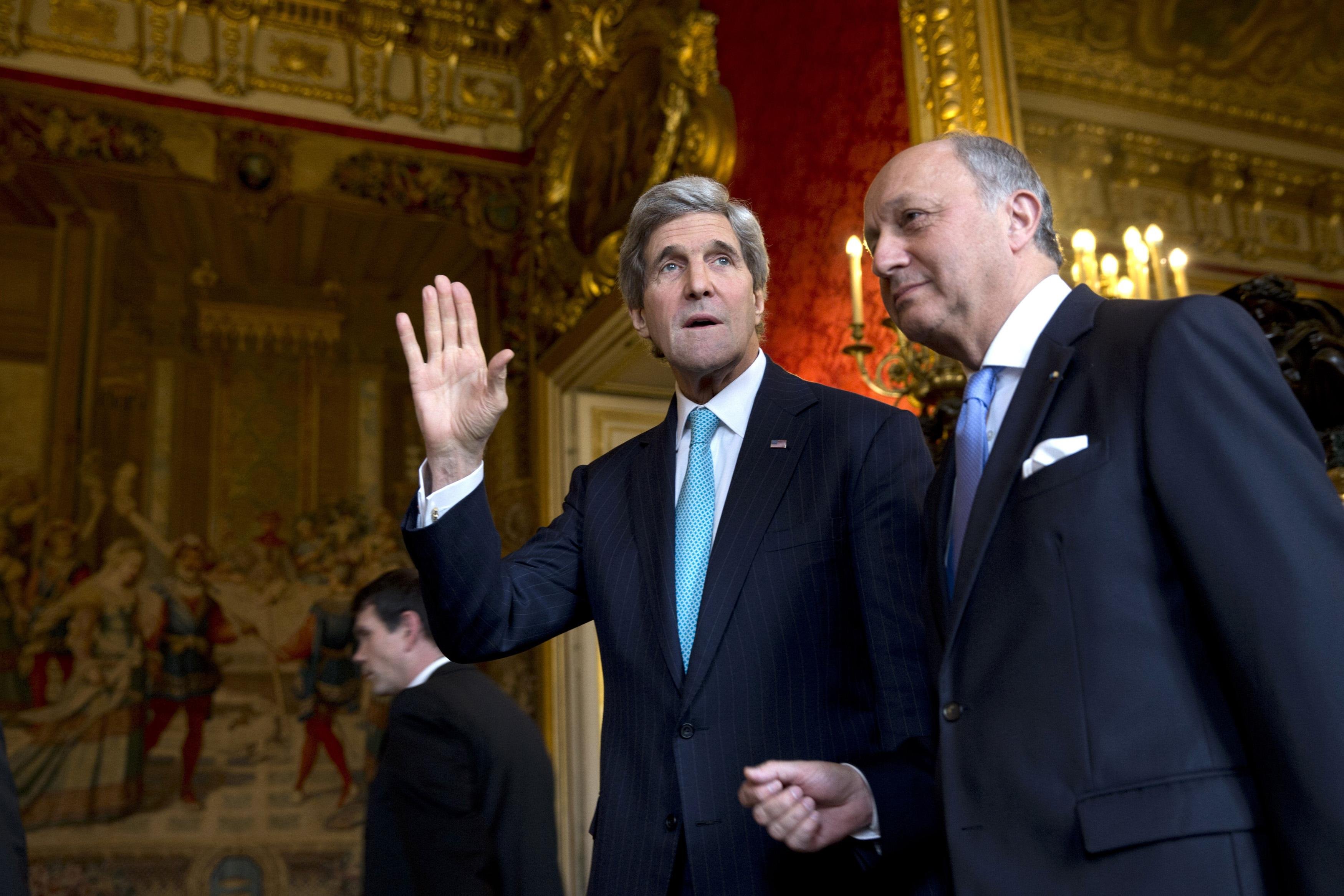 From left: U.S. Secretary of State John Kerry waves to the waiting media as he walks with French Foreign Minister Laurent Fabius for their meeting at the Quai d'Orsay in Paris, on March 30, 2014. (Jacquelyn Martin—Reuters)