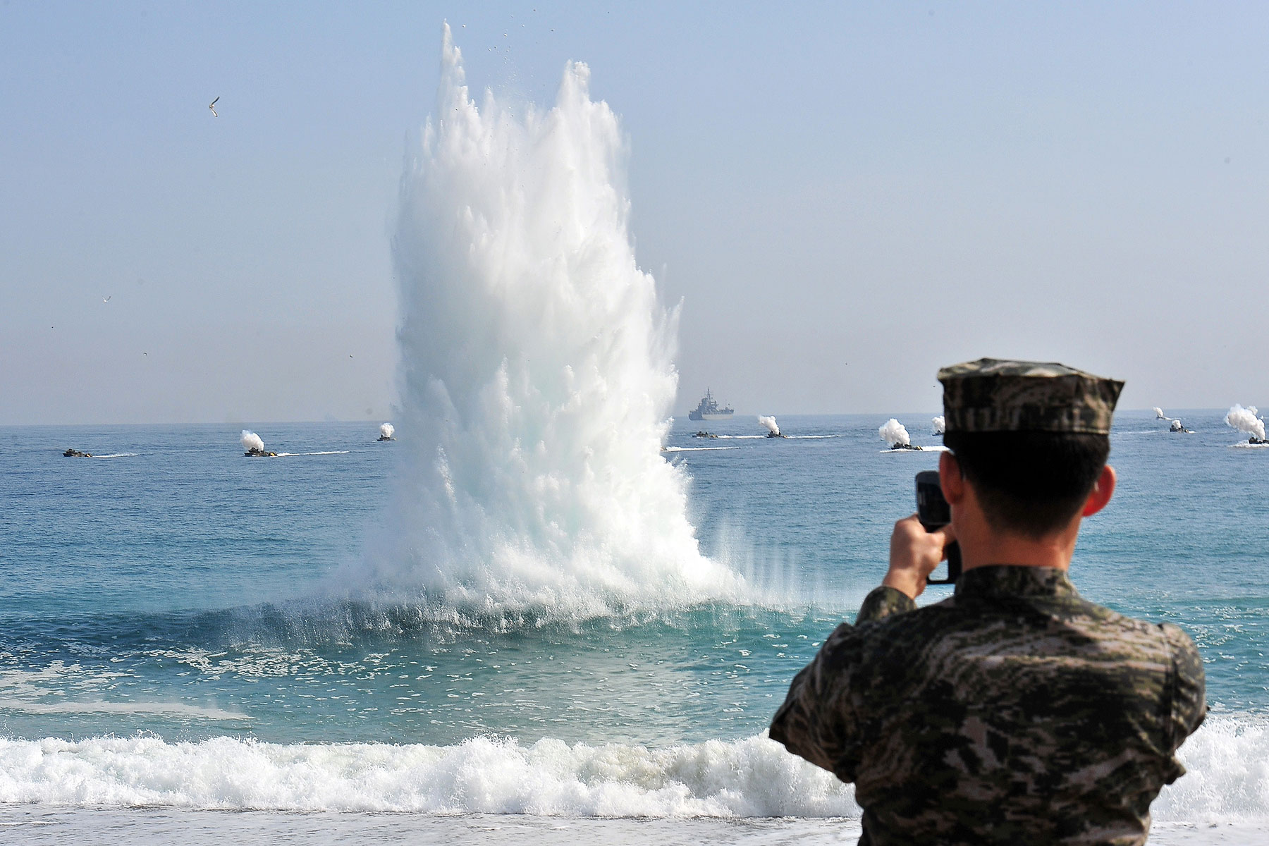 A South Korean Marine stands on a beach as amphibious assault vehicles (in background) approach the seashore during a joint landing operation by US and South Korean Marines in Pohang, 270 kms southeast of Seoul, on March 31, 2014 (JUNG YEON-JE—AFP/Getty Images)