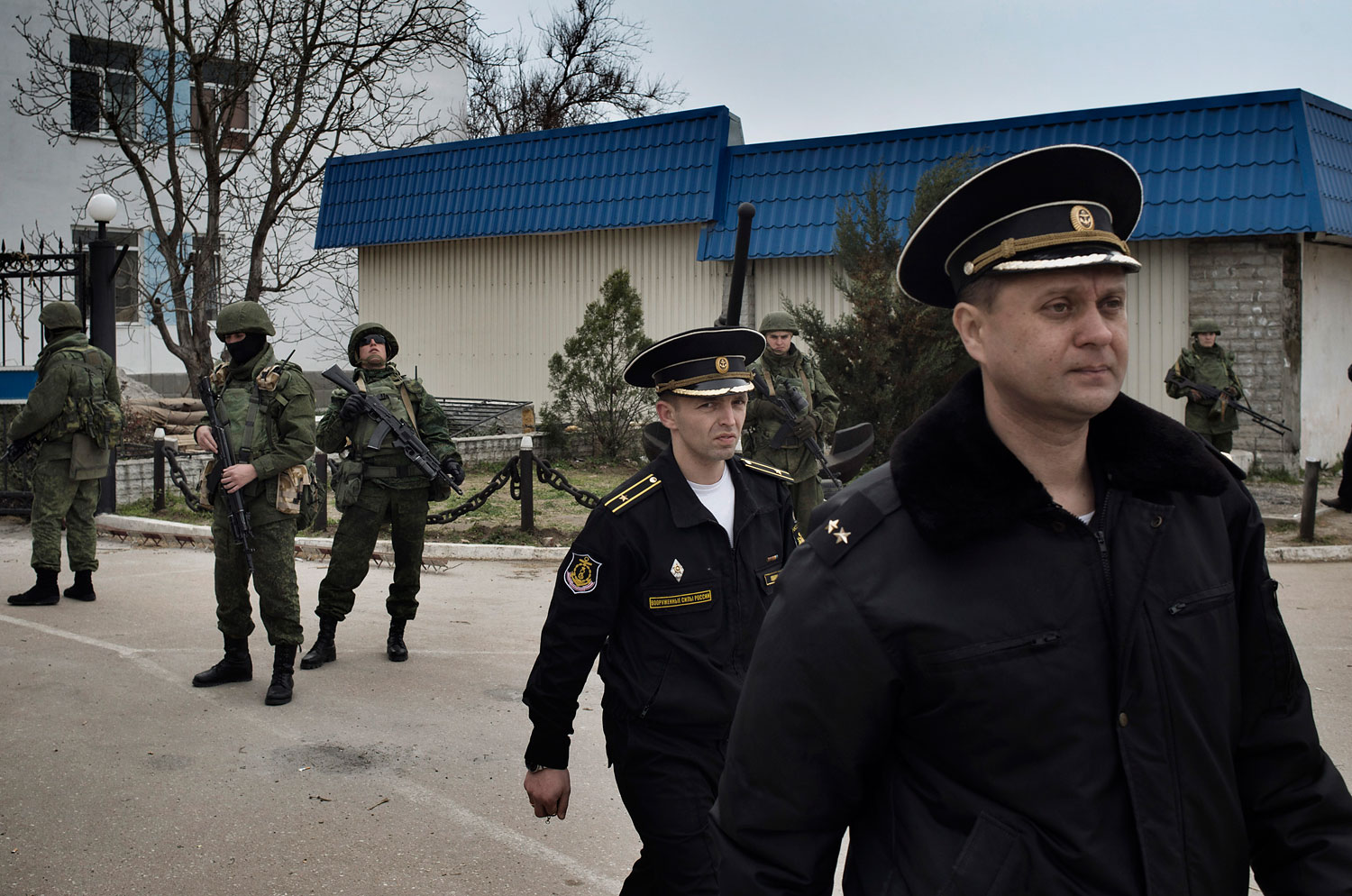 Ukrainian naval officers passed by Russian military personnel as they left the Ukrainian naval headquarters in Sevastopol on Wednesday after Russian forces and local militiamen seized control of the facility, March 19, 2014.
