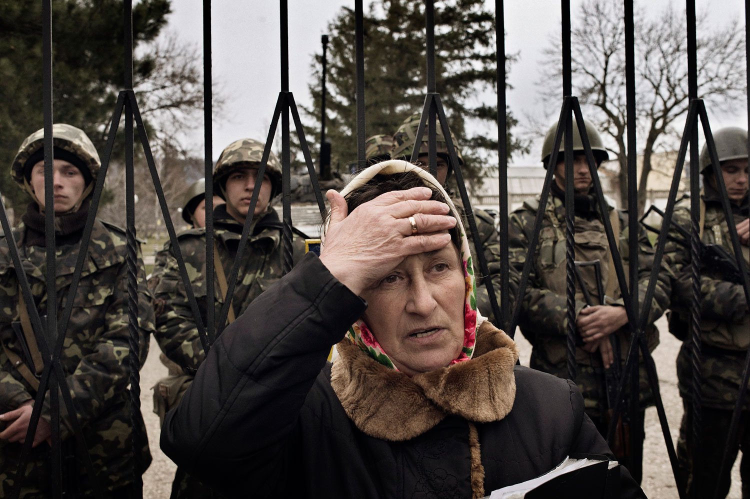 A Ukrainian woman reacts as troops in unmarked uniforms hold positions in Perevalnoye, a small Ukrainian base roughly 15 miles south of Simferopol on Sunday, March 2, 2014. About two dozen Ukrainian soldiers could be seen behind her. (Yuri Kozyrev—NOOR for TIME)