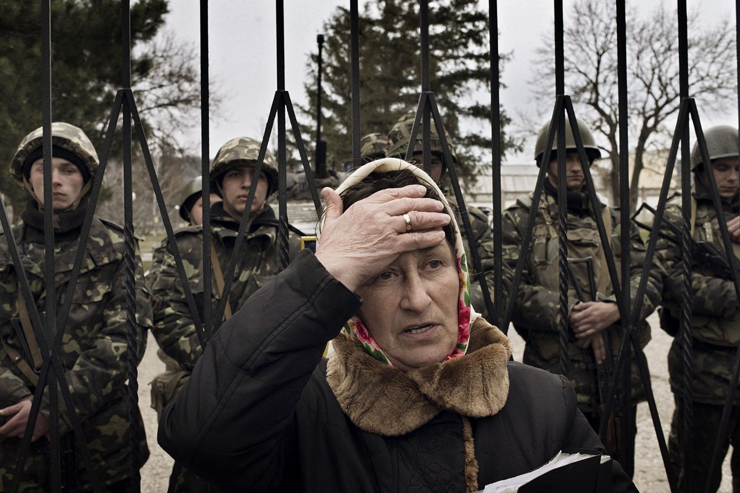 Mar. 2, 2014. A Ukrainian woman reacts as troops in unmarked uniforms  (not pictured) hold positions in Perevalnoye, a small Ukrainian
                              base roughly 15 miles south of Simferopol. About two dozen Ukrainian
                              soldiers stand behind her.