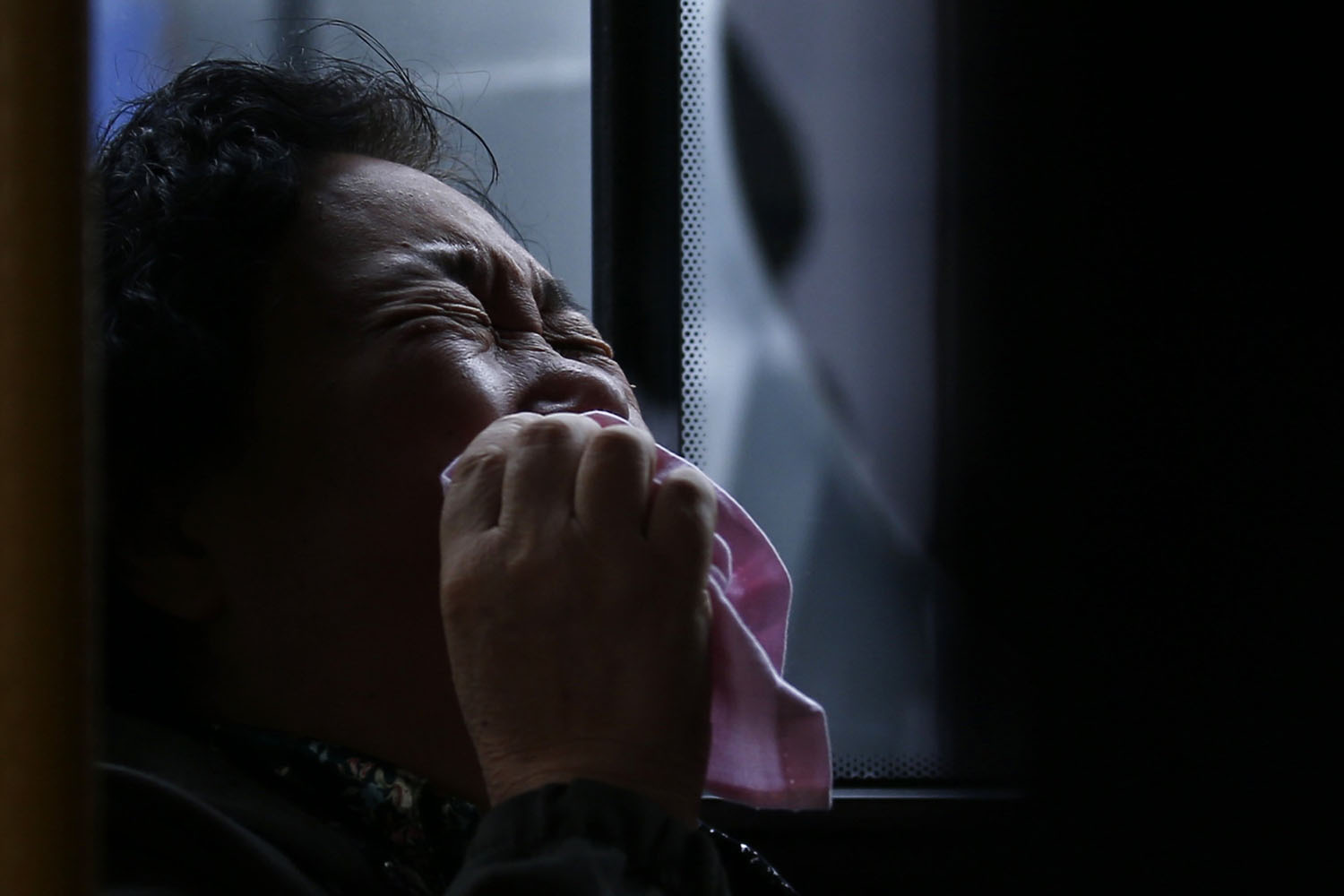 A family member of a passenger onboard Malaysia Airlines Flight MH370 cries on a bus before heading to the Malaysian embassy, outside Lido Hotel in Beijing