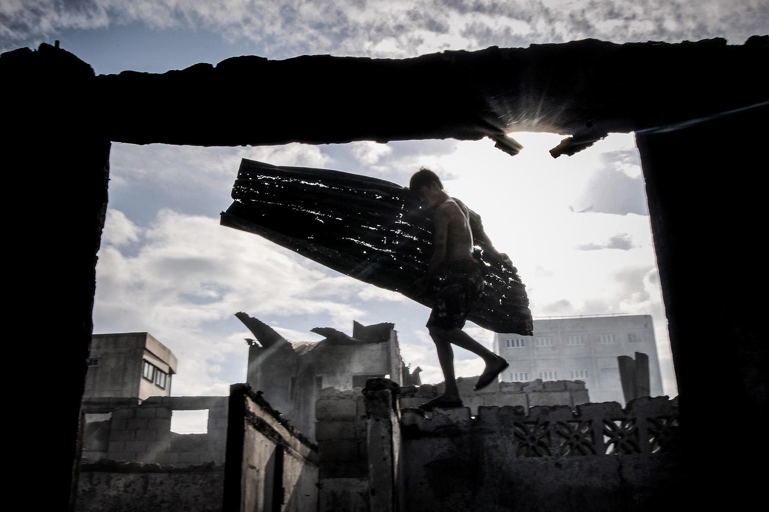 Mar. 23, 2014. A resident collects scrap metal from the rubble of burnt shanties after a fire gutted a residential area in Caloocan city, north of Manila, Philippines.