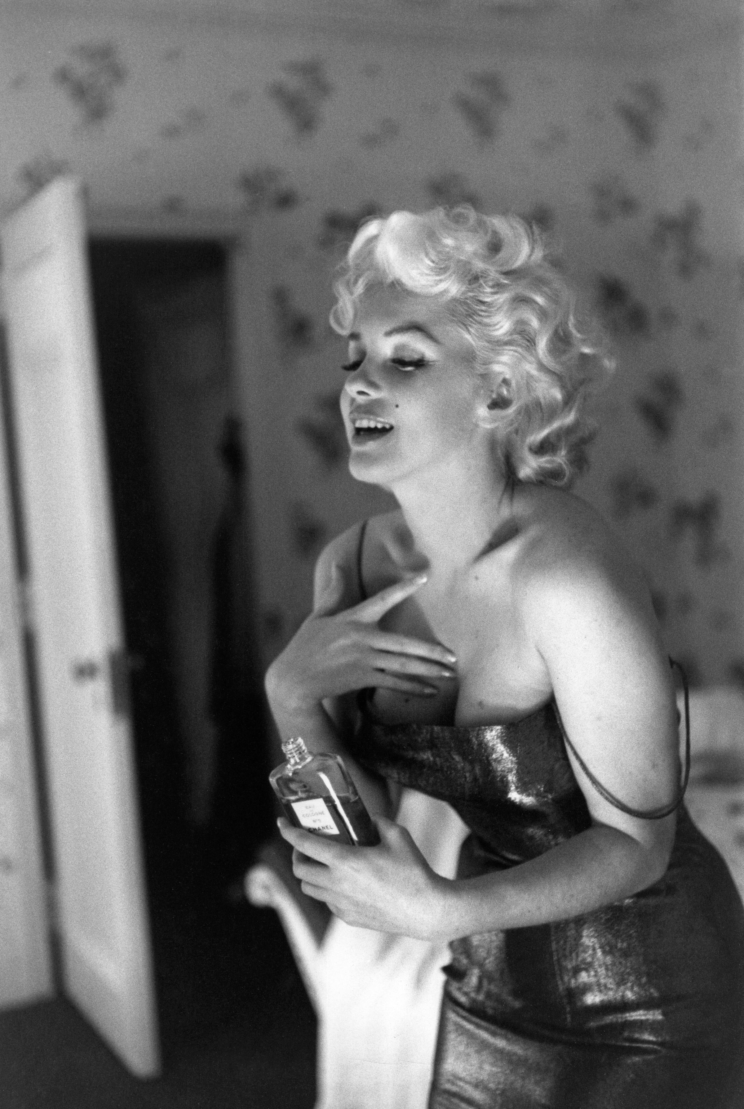 Monroe dabs on some of Coco Chanel's famous perfume while getting ready to go see Cat on a Hot Tin Roof. In a famous quote, when asked what she wore to bed, the screen siren answered, "Chanel No. 5, of course."