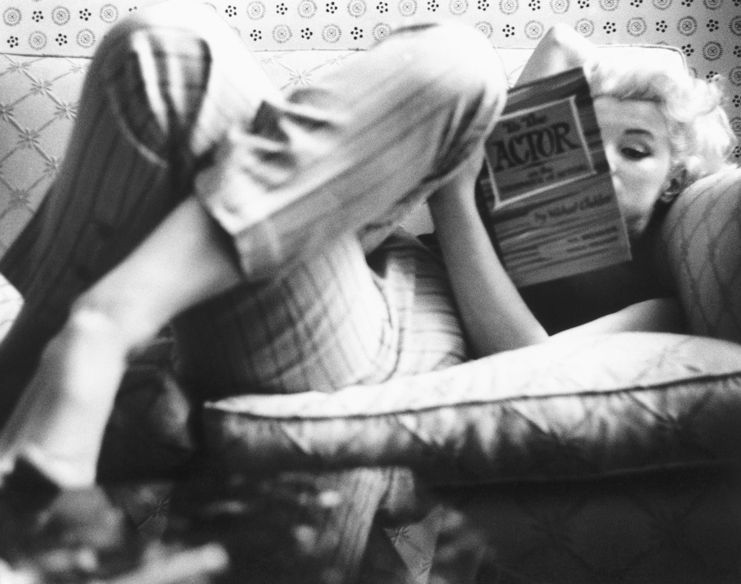 In a New York restaurant in 1955, Monroe immerses herself in a book while reclining on a cozy couch. While known for her dumb-blonde roles, she was in fact very well-read.