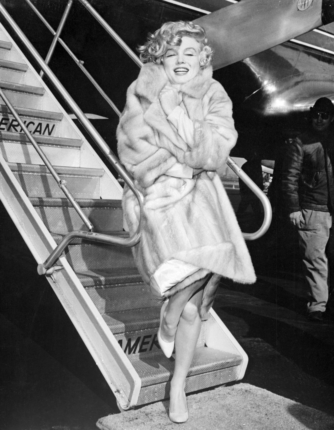 Monroe snuggles into her fur coat to escape the icy winds at La Guardia airport in New York City in 1959.