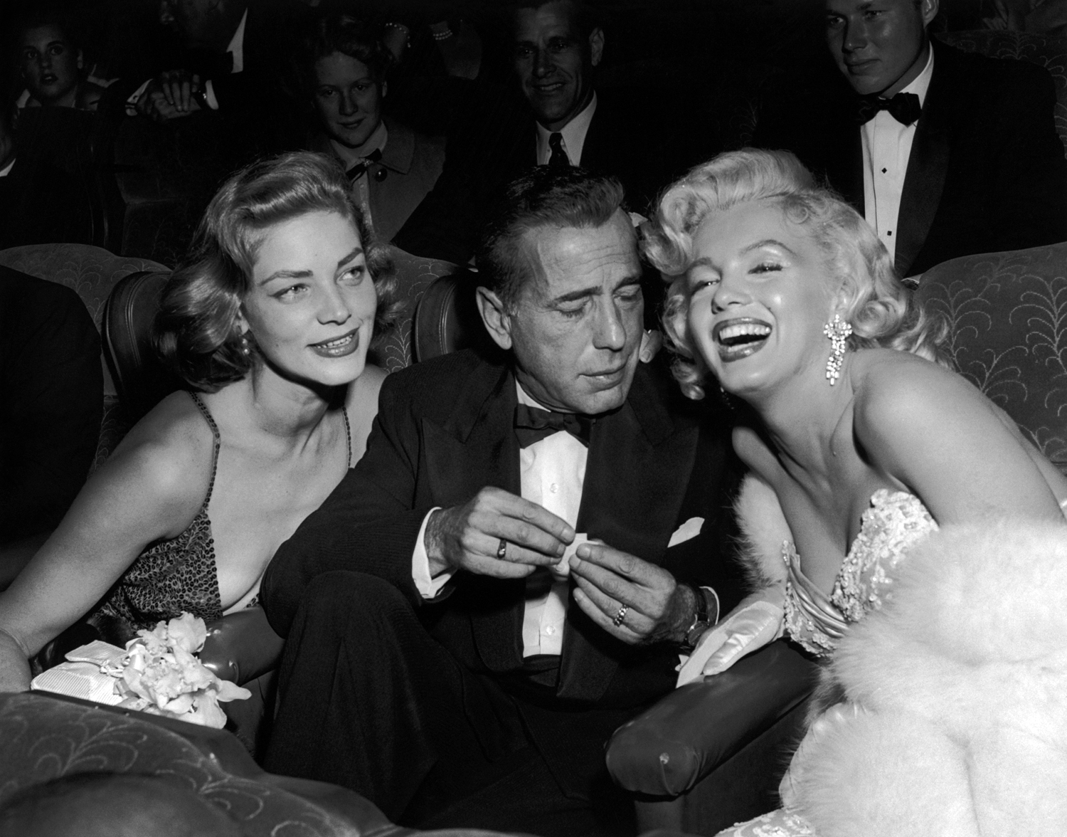 Monroe poses alongside Lauren Bacall, far left, and Humphrey Bogart at the premiere of How to Marry a Millionaire in 1953.