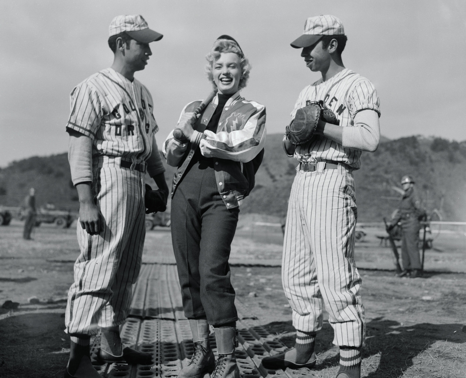 In South Korea in 1954, Monroe poses with baseball players.