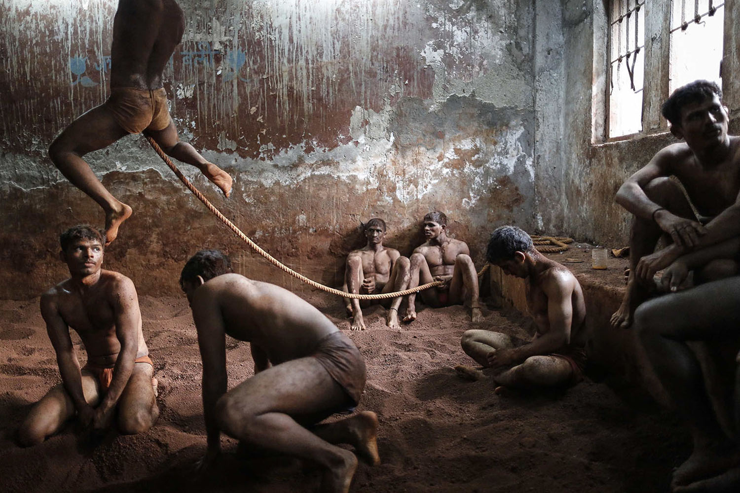 Mar. 4, 2014. Wrestlers practice as others rest in the mud at a traditional Indian wrestling center in Mumbai.