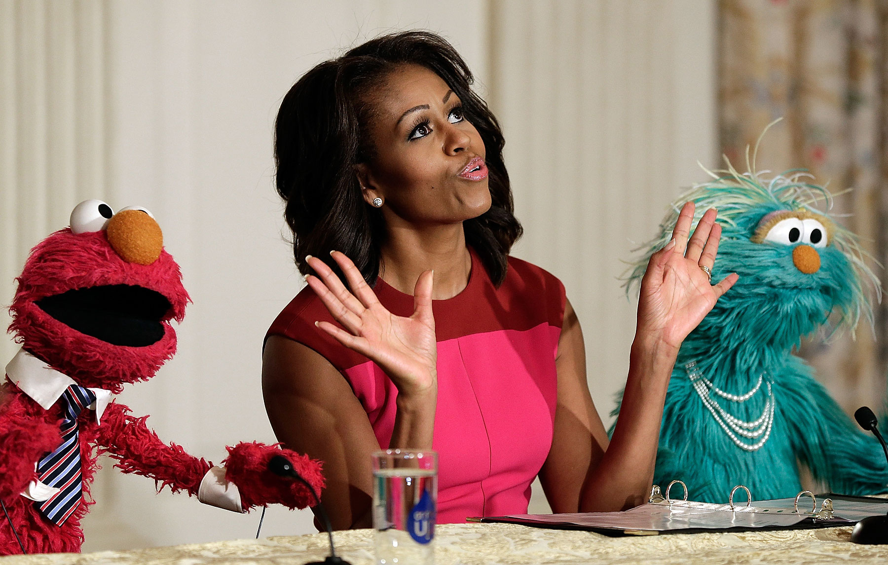 First lady Michelle Obama joins with Sesame Street's Elmo, left, and Rosalita for an announcement on a new initiative aimed at promoting healthier nutrition for school children on Octiber 30, 2013 in Washington, DC.