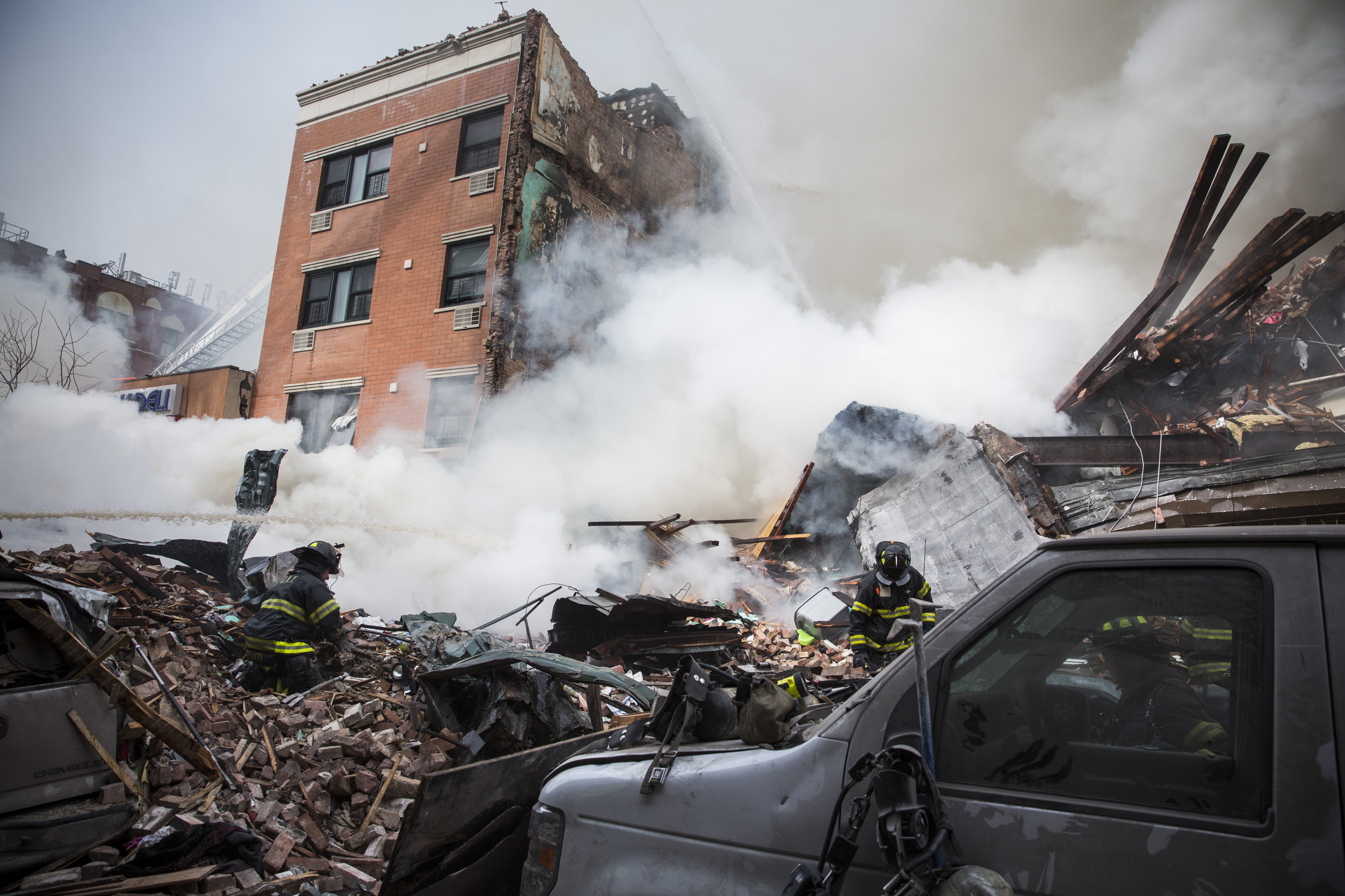 Smoke pours from the debris as the New York City Fire Department responds to a fire and building collapse at 1646 Park Avenue in the Harlem neighborhood of Manhattan on March 12, 2014