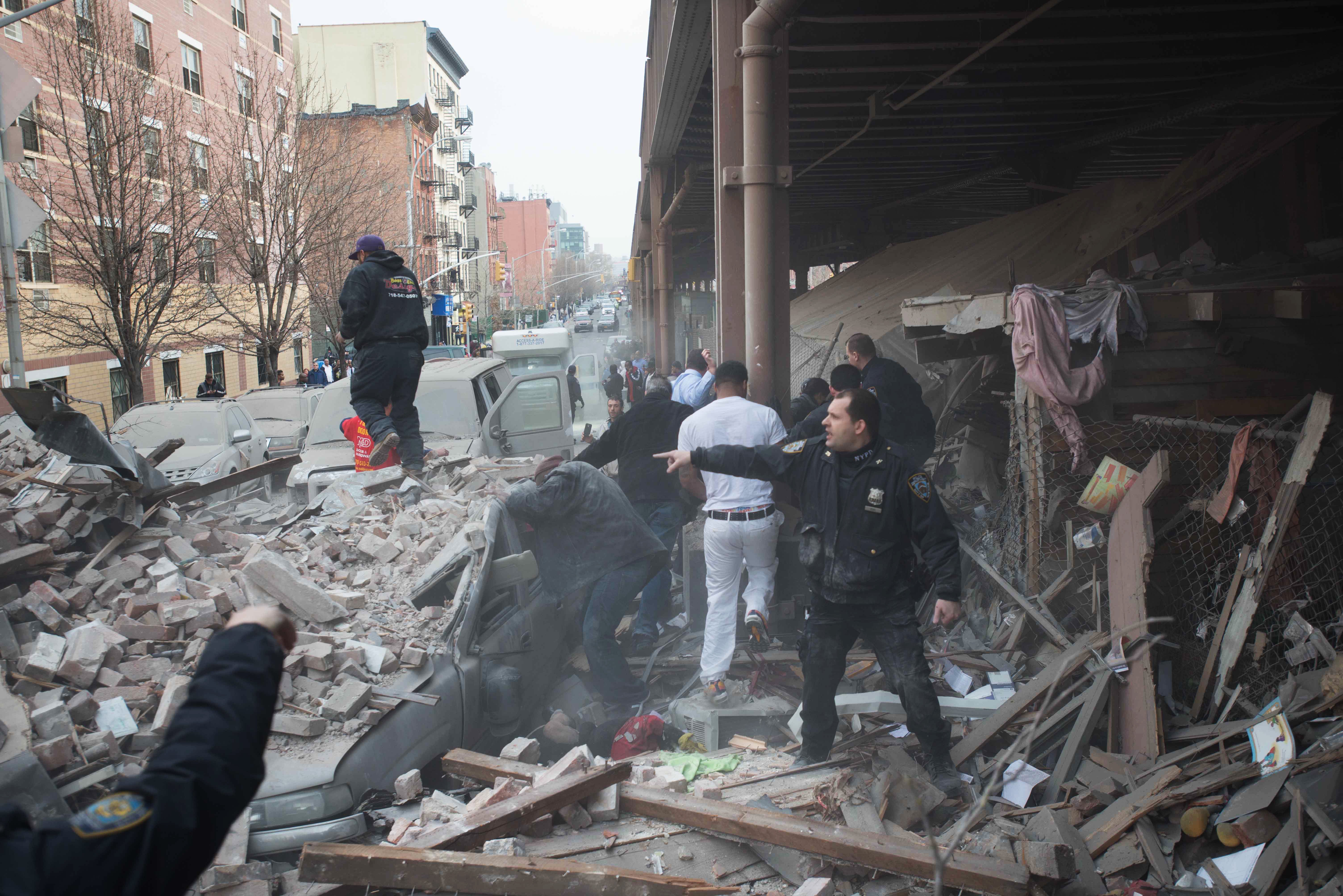 Police respond to the scene of an explosion that leveled two apartment buildings in East Harlem.