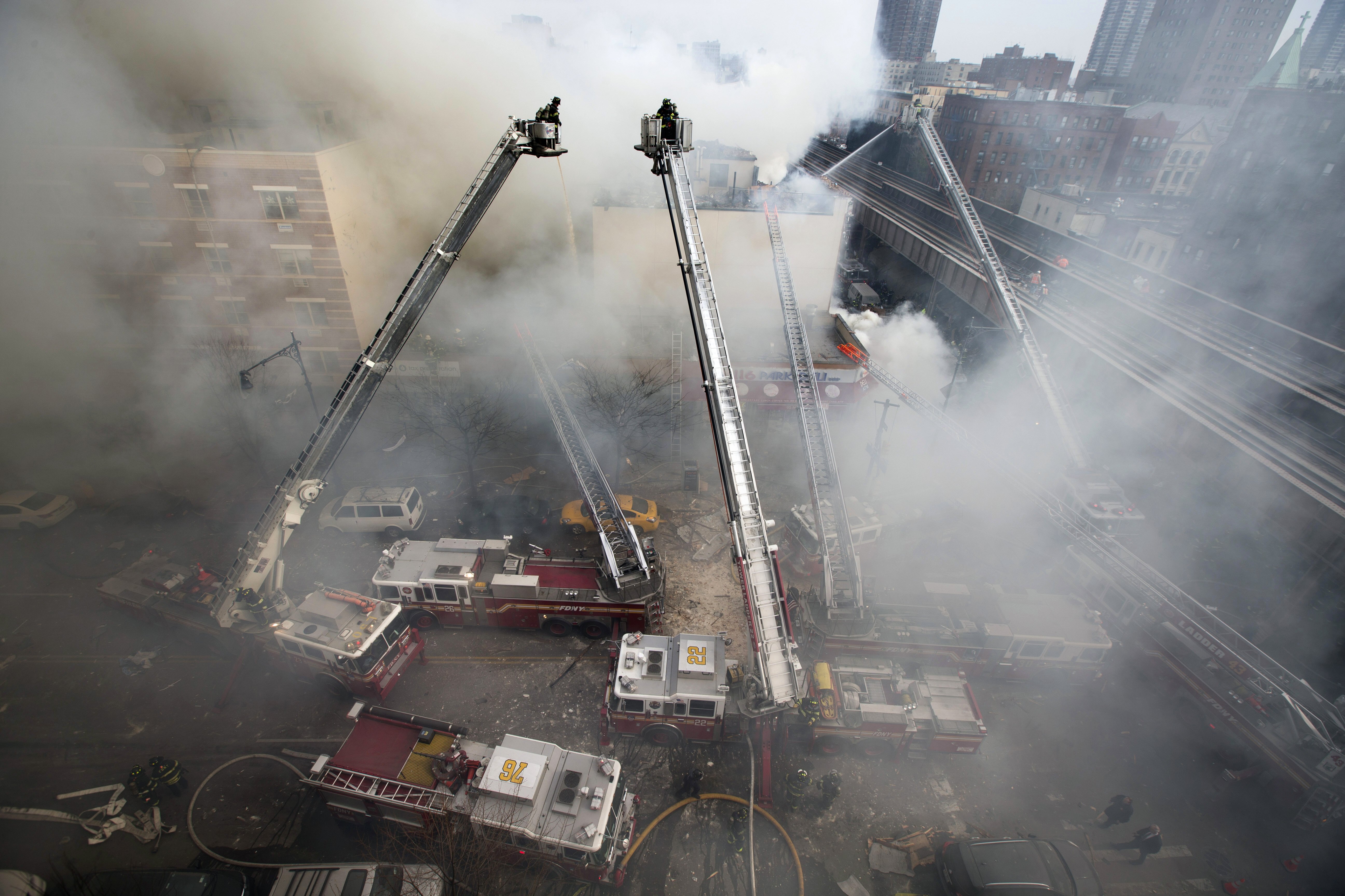 Firefighters respond to an explosion that leveled two apartment buildings in East Harlem.