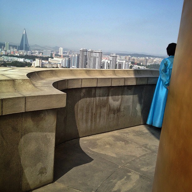 A North Korean tour guide stands on the top of Juche Tower in Pyongyang and looks across the Taedong River at the city below, September 17, 2013.