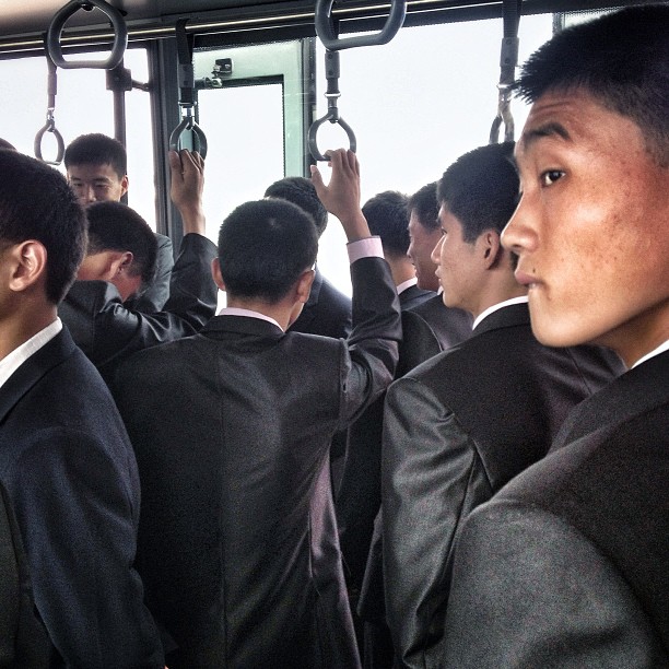 North Korean men on an airport transport bus headed to the Air Koryo flight for Beijing, Pyongyang Sunan International Airport, September 24, 2013.