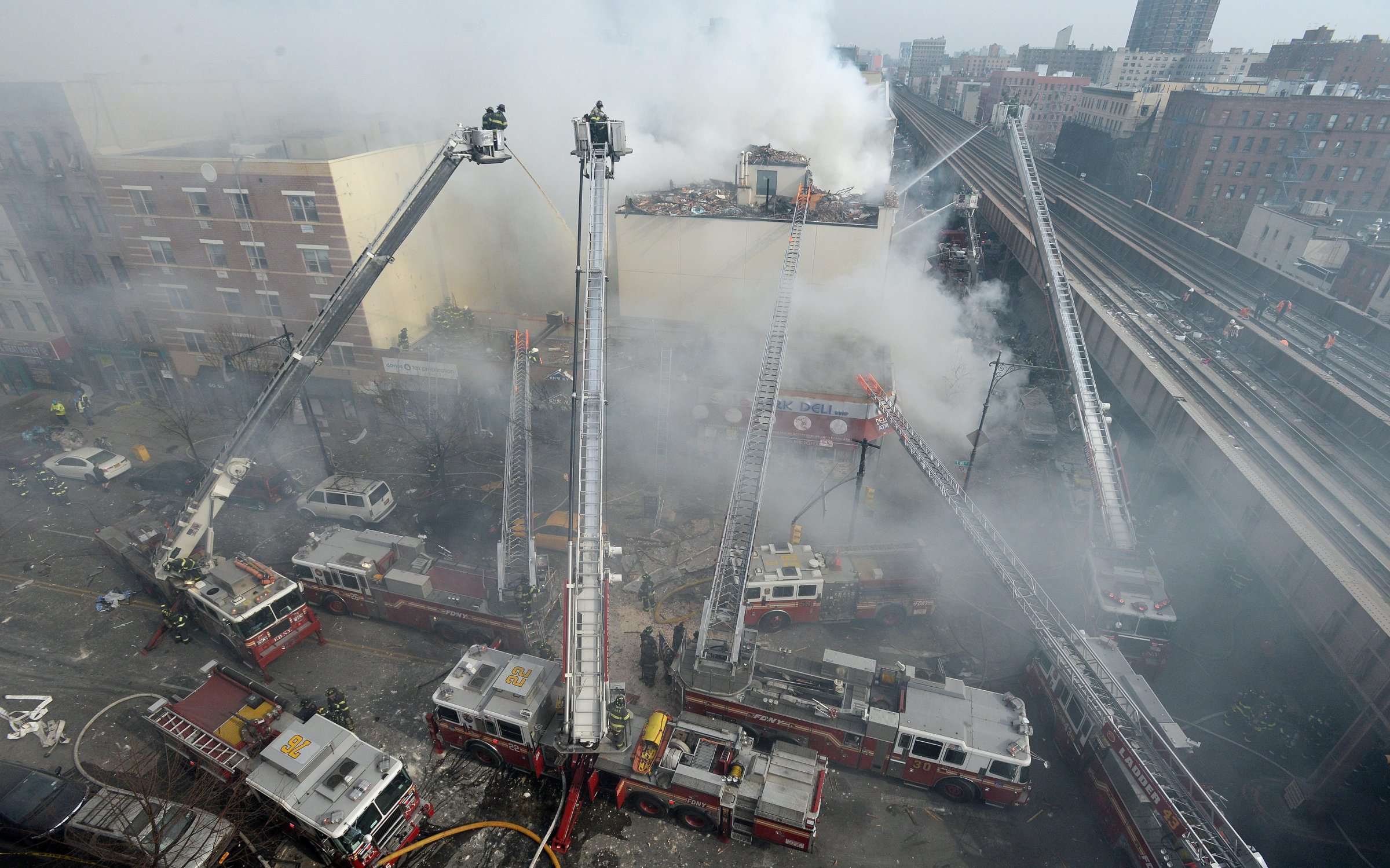 Firefighters extinguish a fire after a reported explosion and building collapse