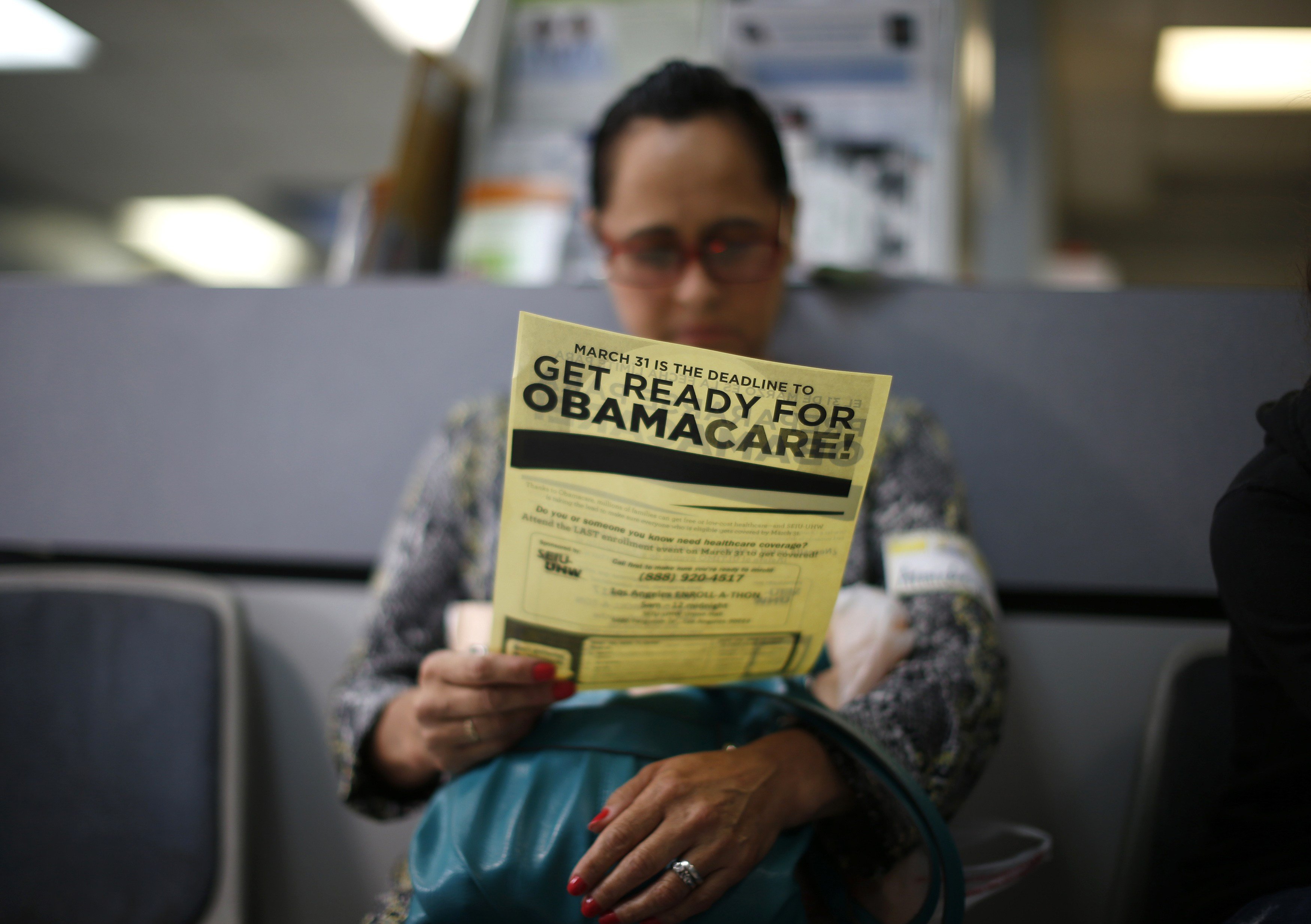 Arminda Murillo reads an Obamacare leaflet at a health-insurance-enrollment event in Cudahy, Calif., on March 27, 2014 (Lucy Nicholson—Reuters)