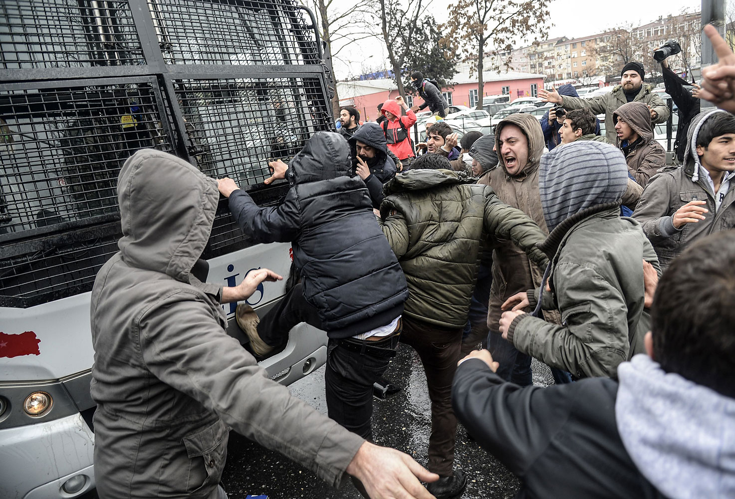 Protesters attack a riot police vehicle during clashes outside Okmeydani Hospital in Istanbul on March 11, 2014.