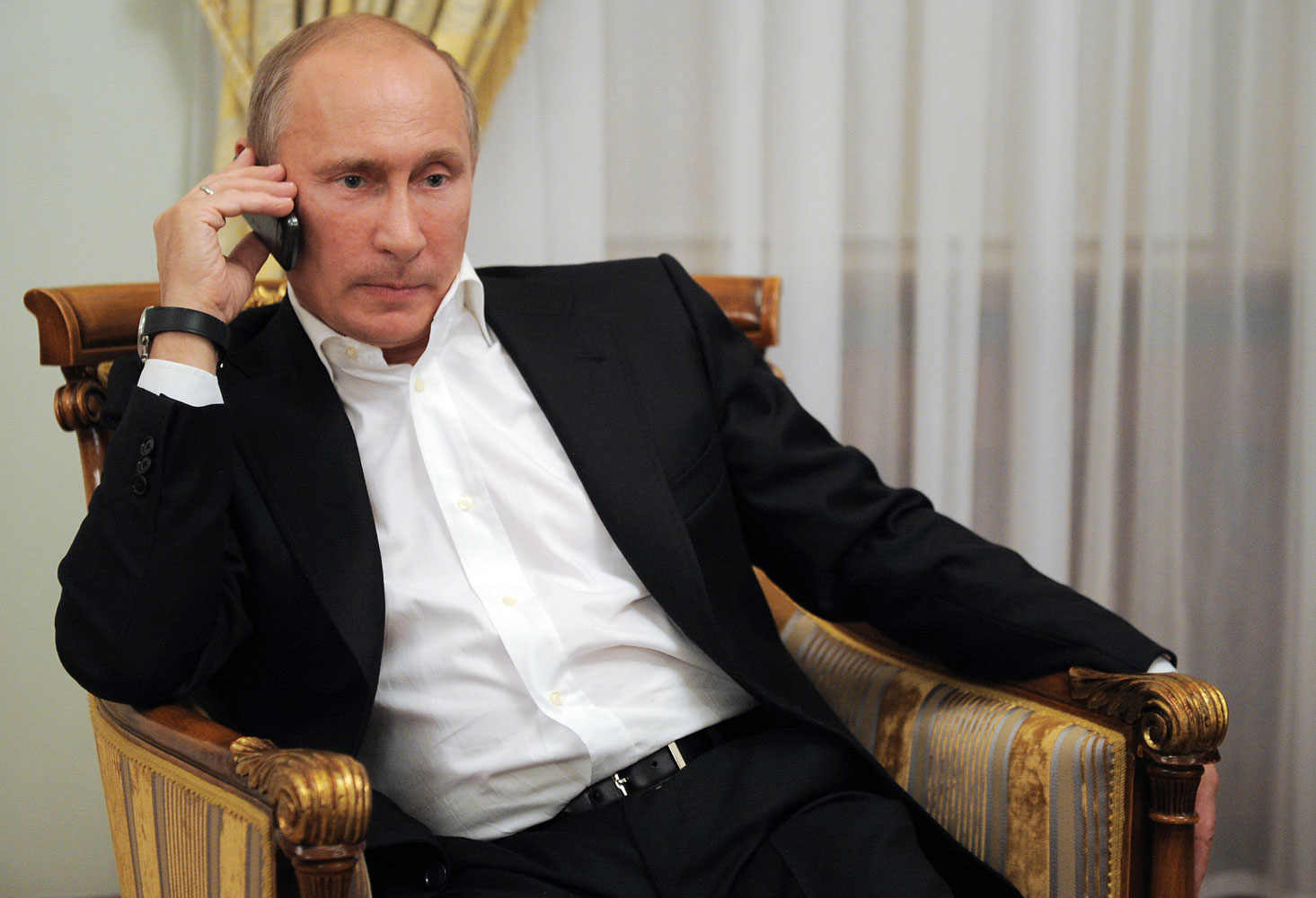 Russian President Putin phones as he watches TV in his residence in Novo-Ogarevo, outside Moscow, in  2012 (Alexey Druzhinin—AFP/Getty Images)