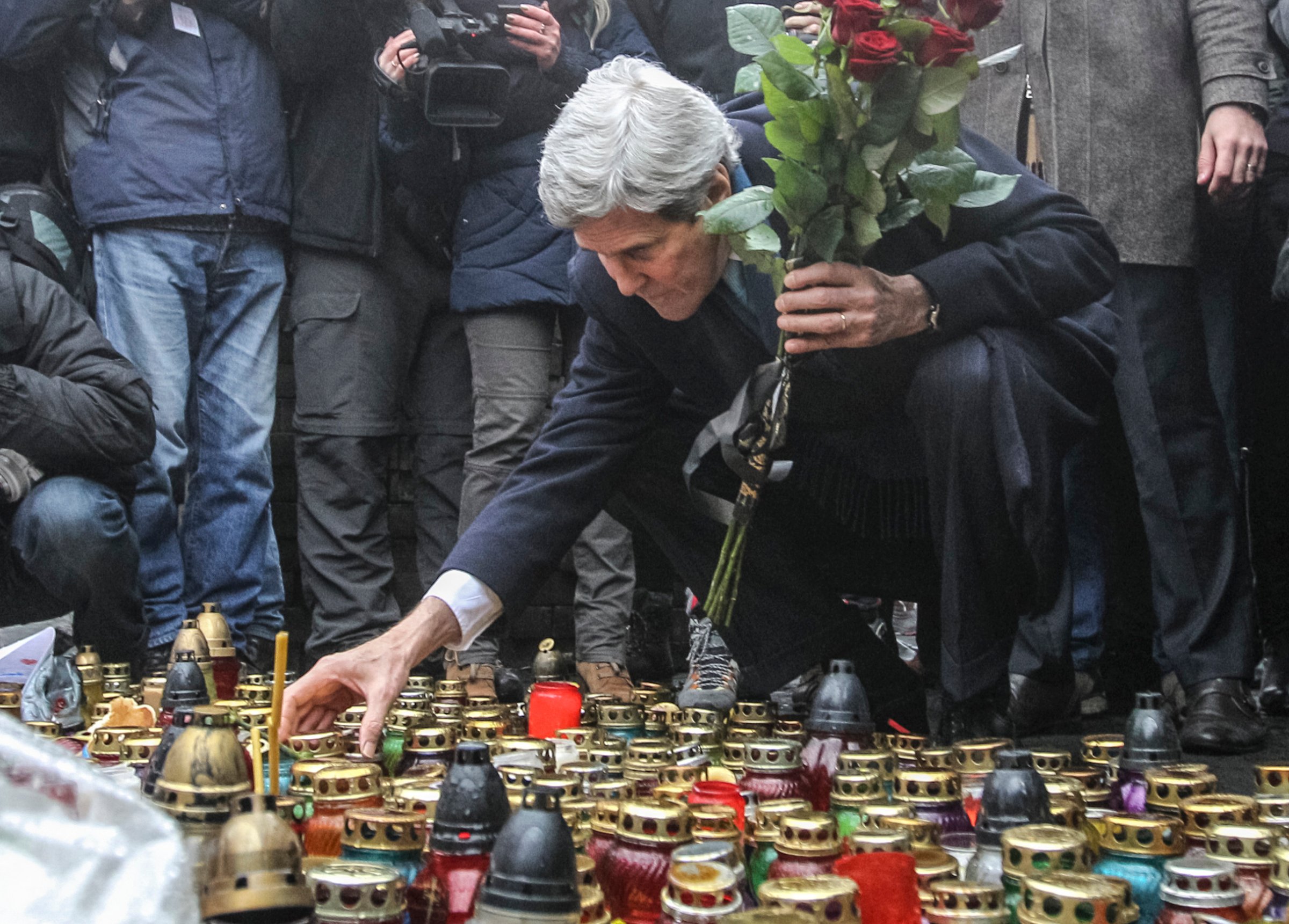 U.S. Secretary of State John Kerry lights a candle and lays roses atop the Shrine of the Fallen in Kiev