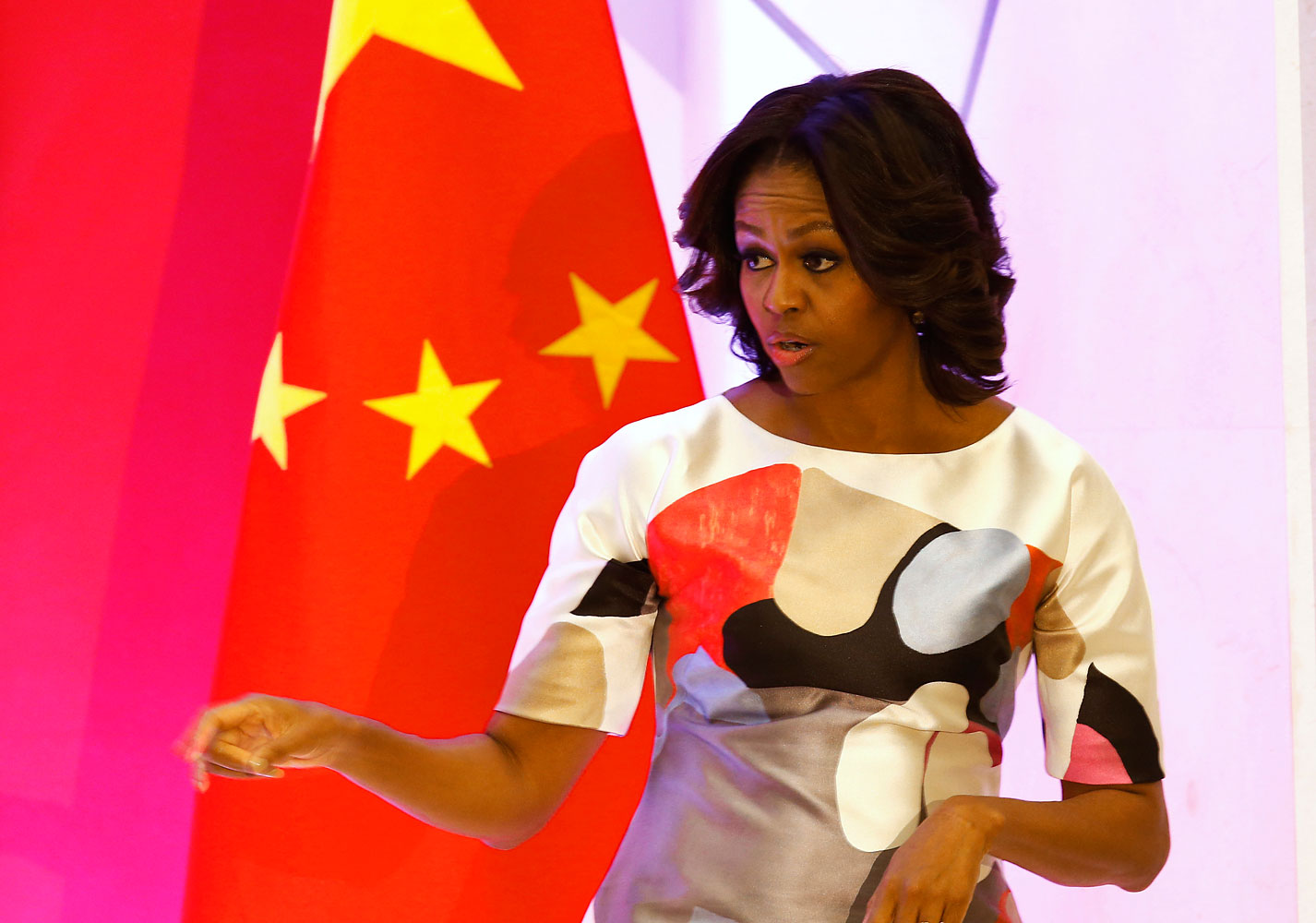 U.S. first lady Michelle Obama gestures in front of a Chinese national flag after giving a speech at the Peking University in Beijing