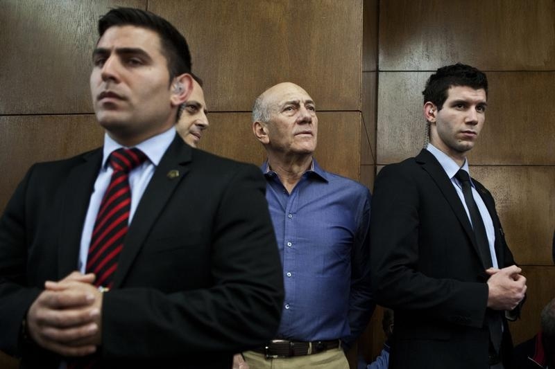 Former Israeli Prime Minister Ehud Olmert (center) waits to hear his verdict at the Tel Aviv District Court on March 31, 2014.