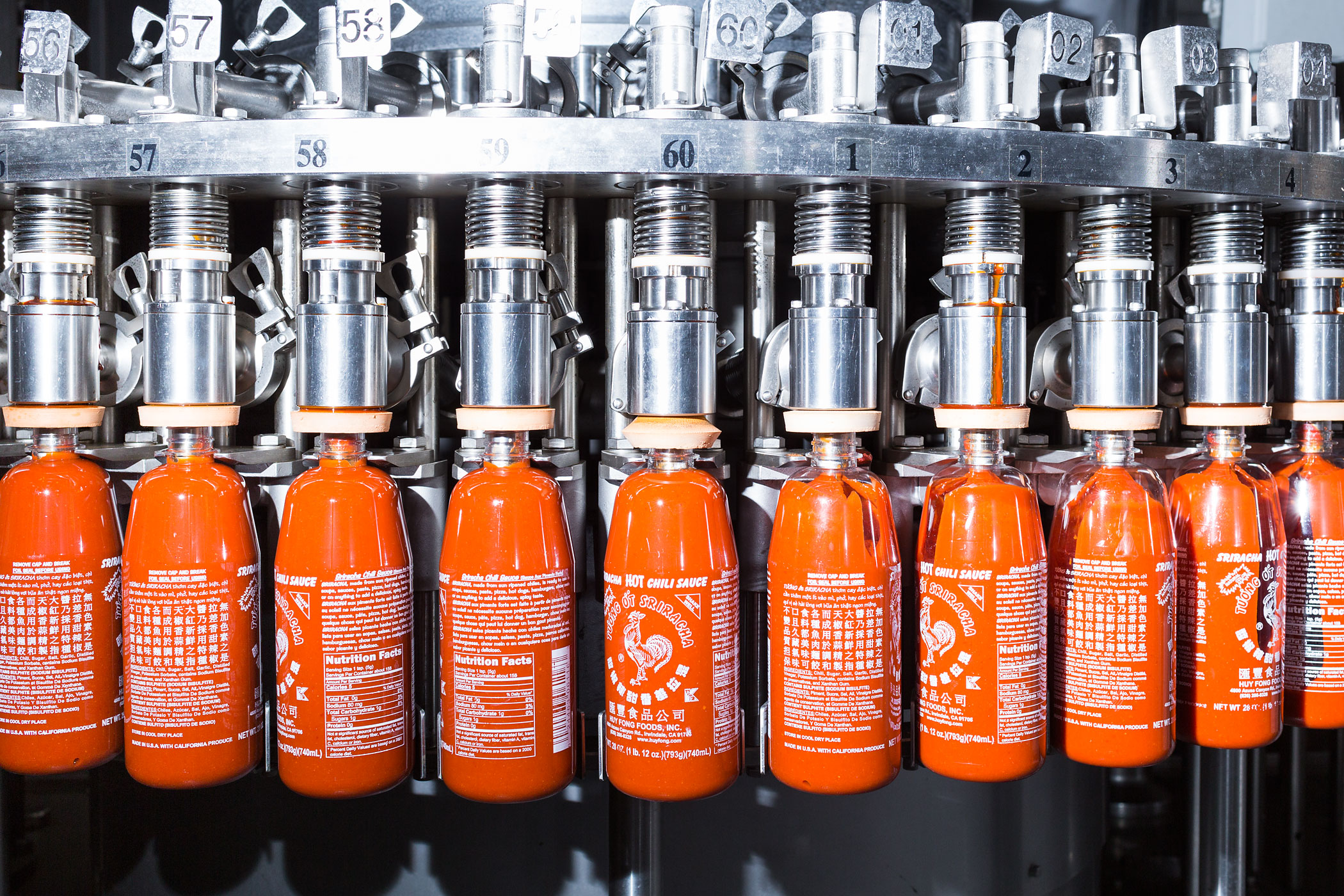 Bottles of Sriracha being filled. When CEO and founder David Tran started making chili sauce in Vietnam, he and his family hand-filled bottles with spoons.