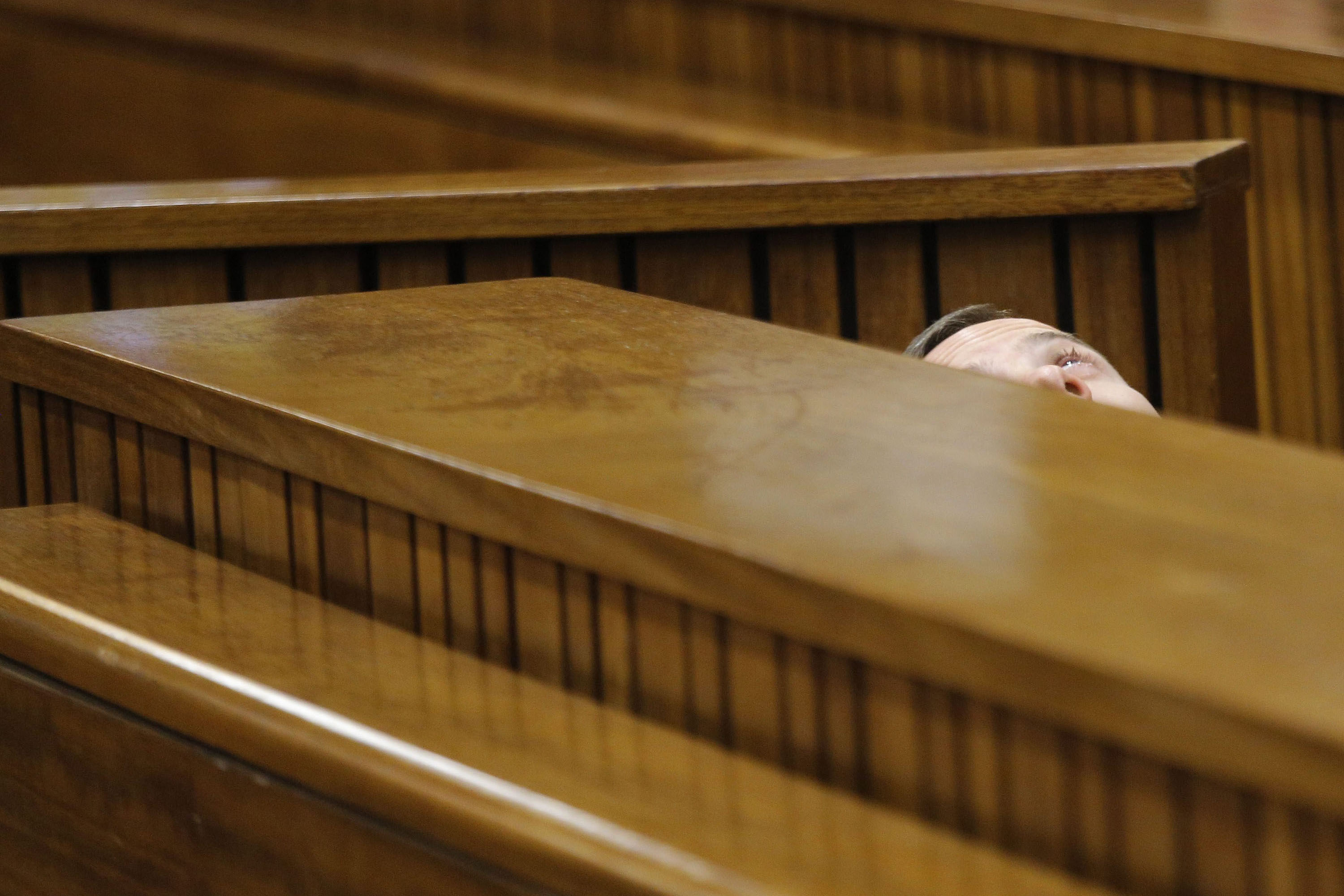 South African Paralympic athlete Oscar Pistorius is seen leaning back after applying eye drops as he prepares himself for another day in the dock during his ongoing murder trial in Pretoria, South Africa, March 14, 2014.